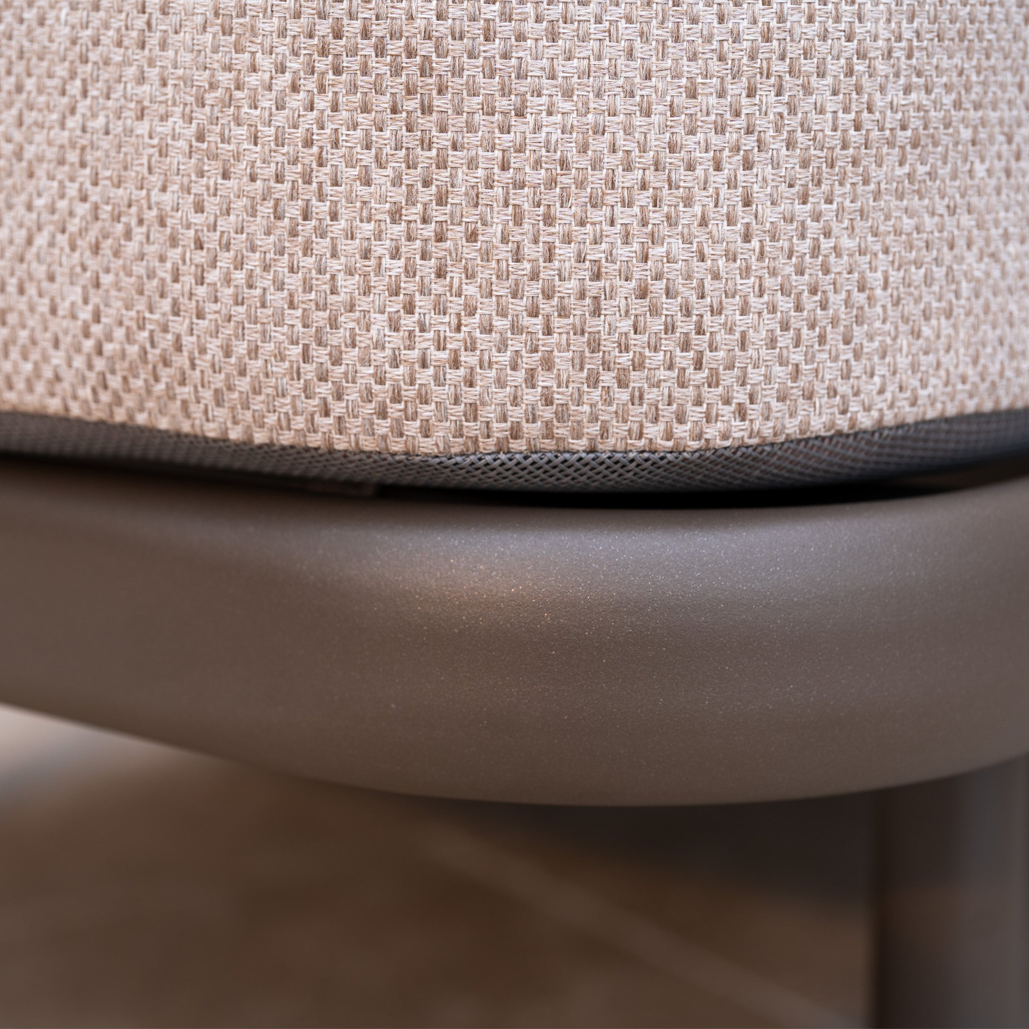 Close-up of a beige textured fabric cushion on the smooth, curved metal frame of the Sofia Sunlounger with Headrest and Wheels in Putty.