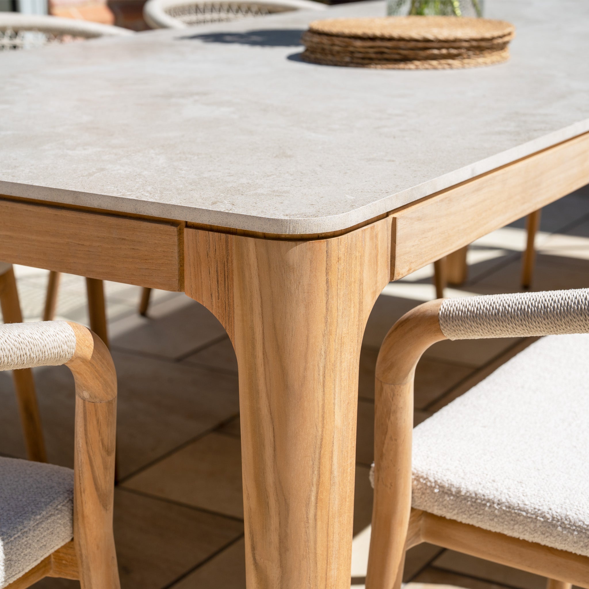 Close-up of the Sora 8 Seat Rope Dining Set featuring a ceramic stone top table and cushioned chairs, perfect for stylish patio gatherings.