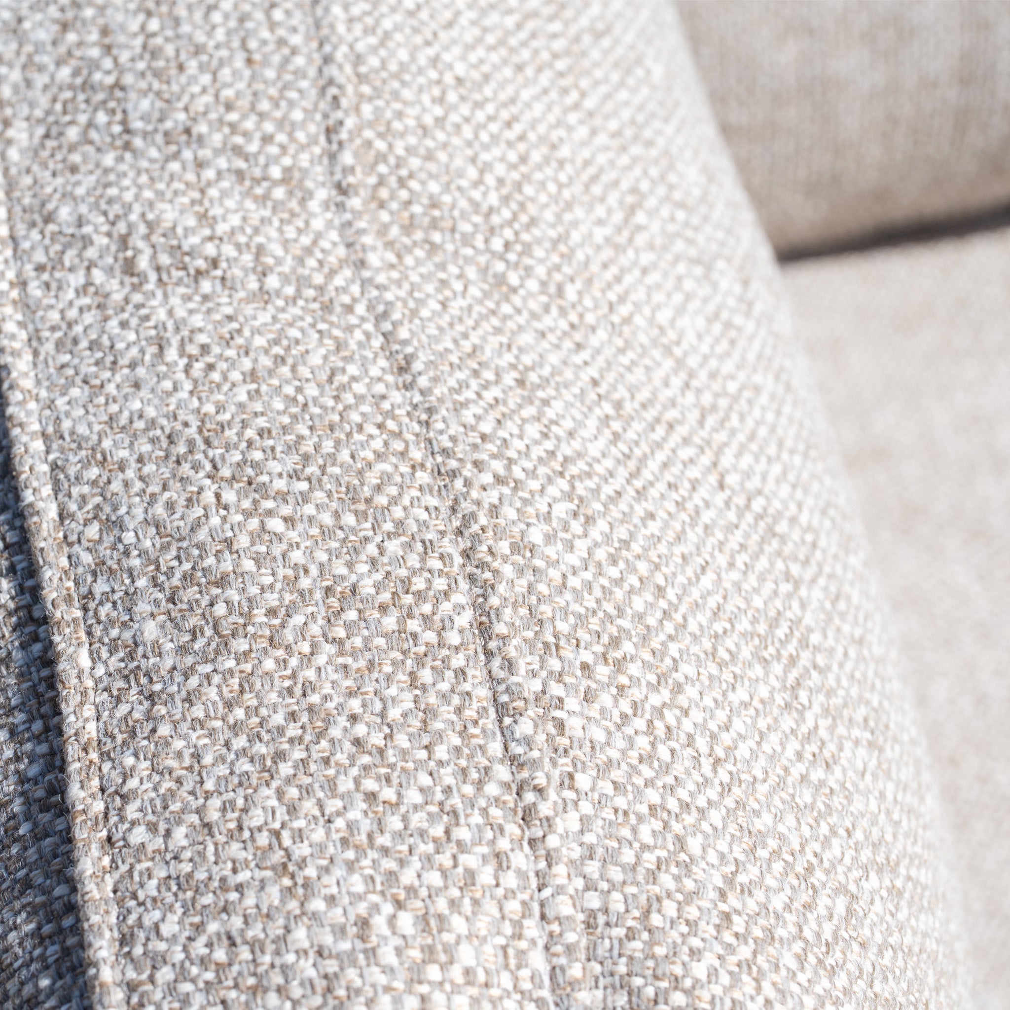 Close-up of beige textured fabric upholstery with visible stitching on the Sorelli 2 Seat Sofa Set in Oatmeal, a weather-resistant garden furniture piece.