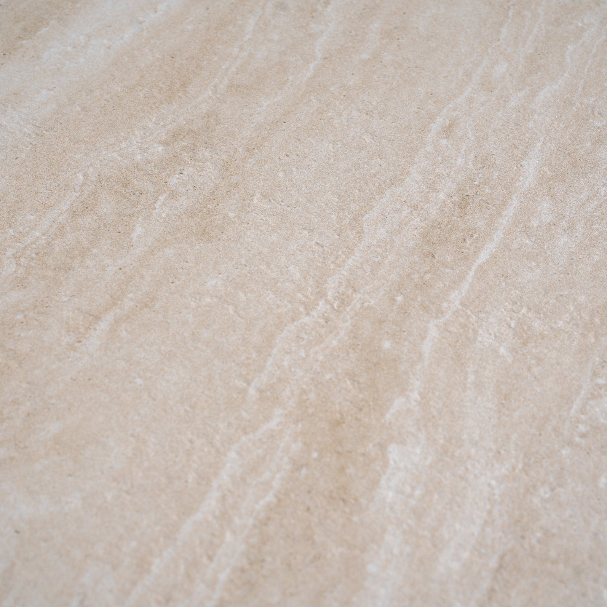 Close-up of a beige stone surface with natural light and wavy textured lines—a refined backdrop ideal for displaying the Sorelli 2 Seat Sofa Set in Oatmeal or other weather-resistant garden furniture.