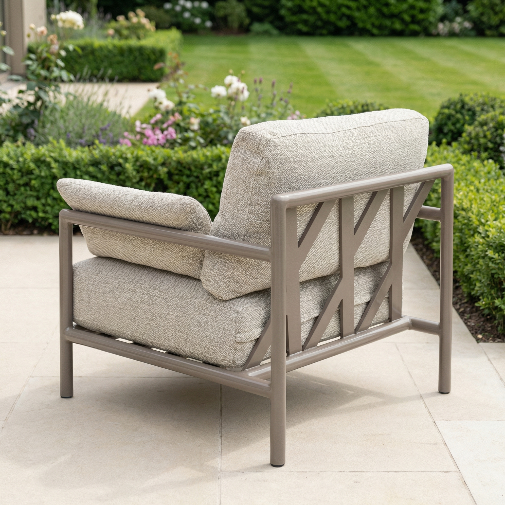 The Sorelli Armchair in Oatmeal is a cushioned outdoor chair with a metal frame, designed for durability and comfort—ideal for relaxing on patios or in gardens.