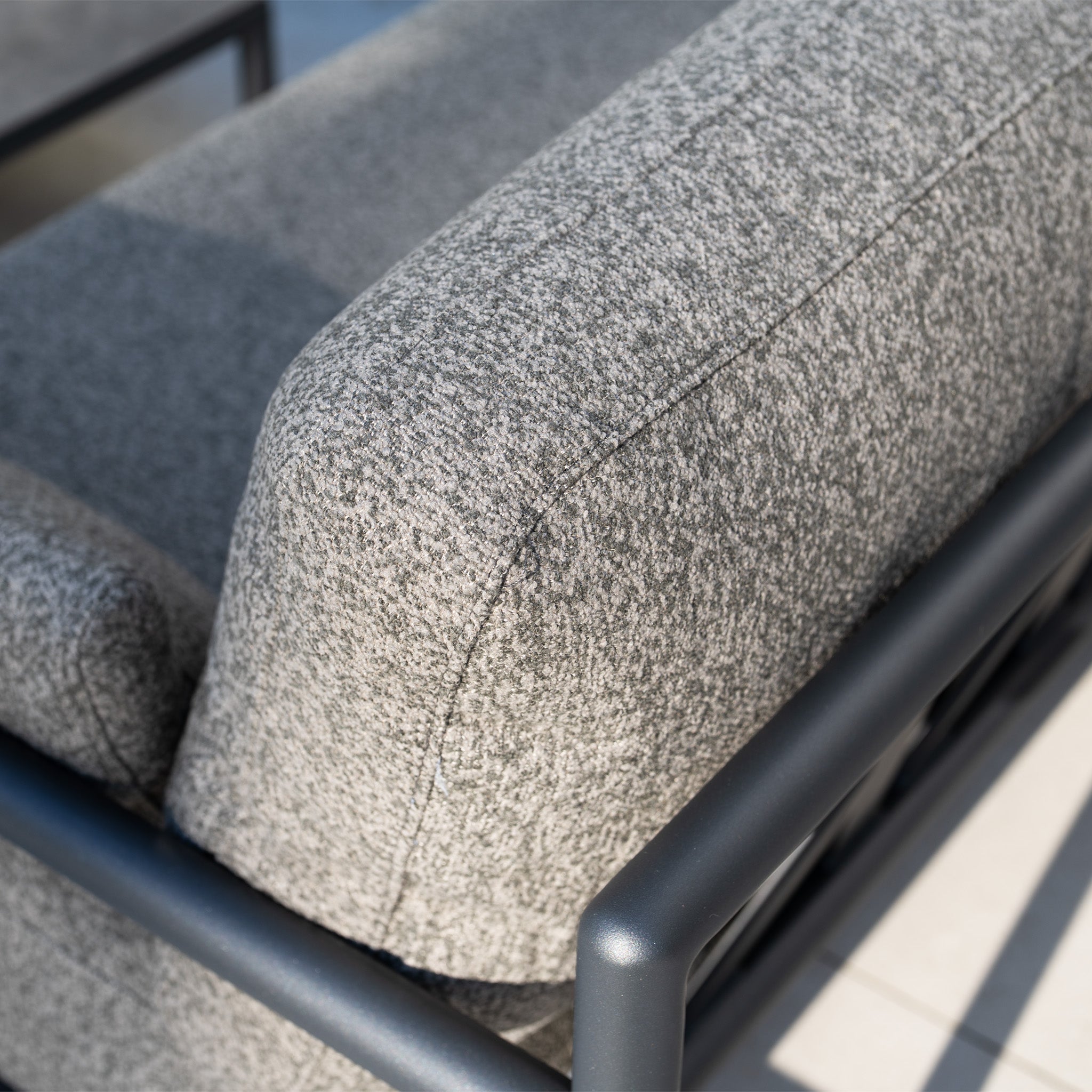 Close-up of the Sorelli 2 Seat Sofa Set in Truffle—a modern gray outdoor sofa with black aluminum frame—shown in natural light.