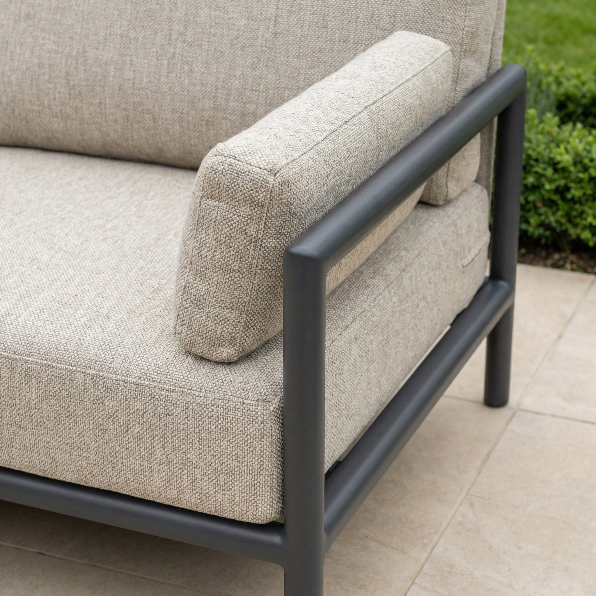 Close-up of the Sorelli U Shape Corner Sofa Set in Truffle, featuring a metal frame and weather-resistant cushions on a tiled patio, perfect for outdoor entertaining with greenery in the background.