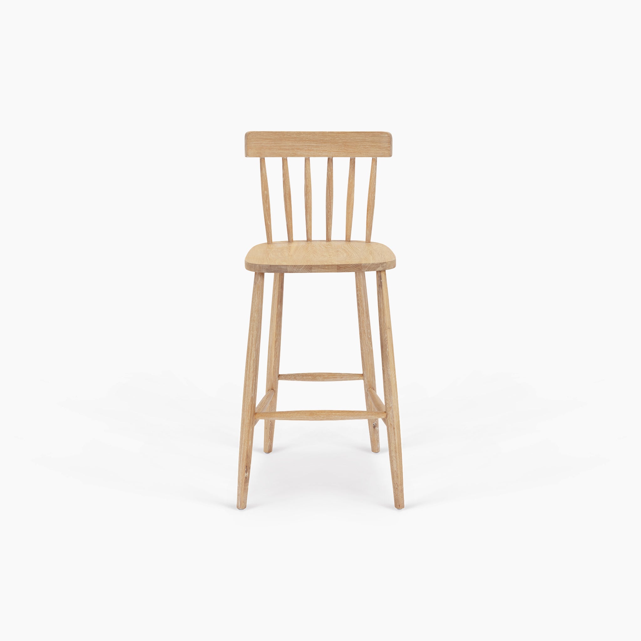 The Burford Spindleback Bar Stool in Natural Oak features a slatted backrest and four legs, shown against a plain white background.