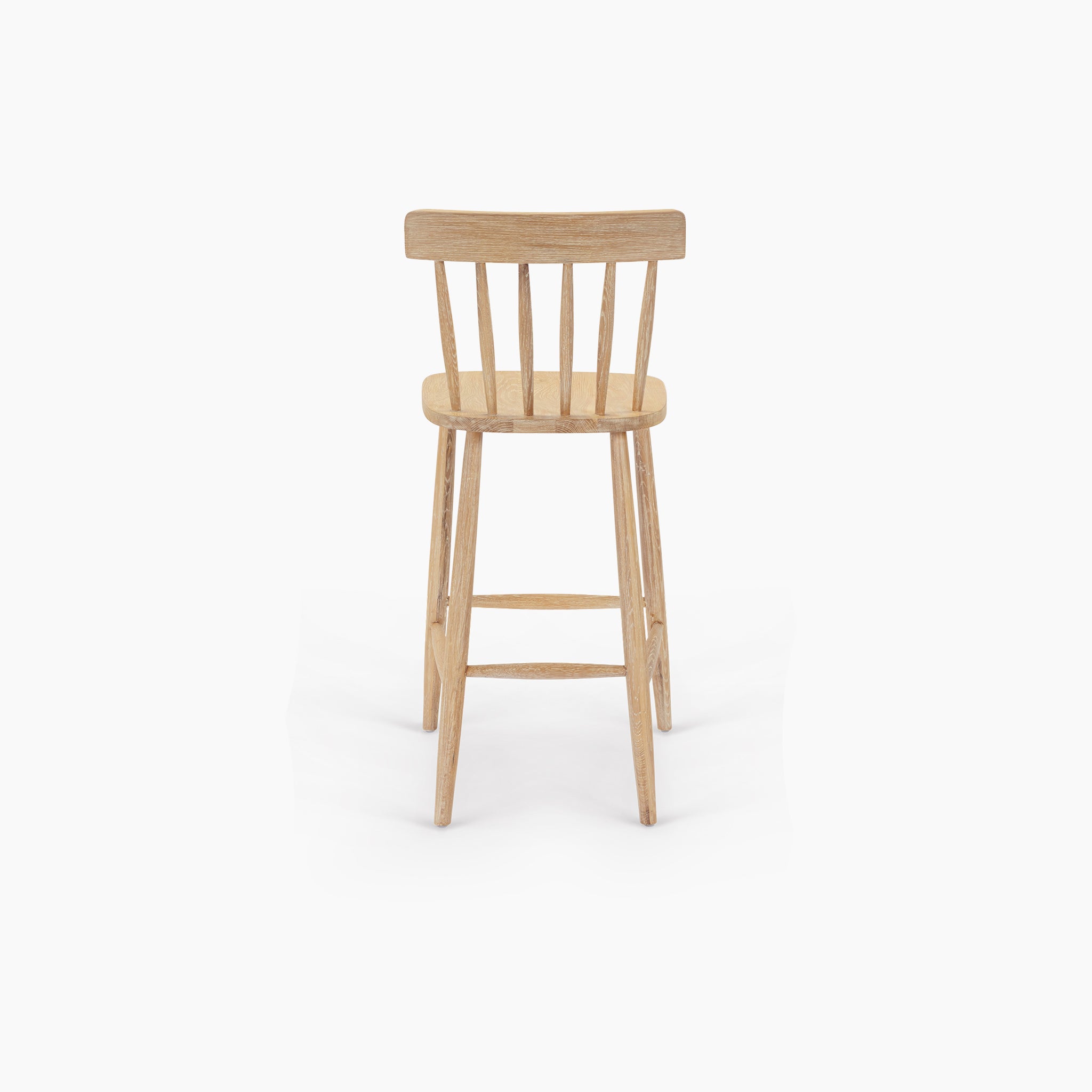 The Burford Spindleback Bar Stool in Natural Oak features a light wooden frame with a curved backrest and vertical slats, displayed against a plain white background.