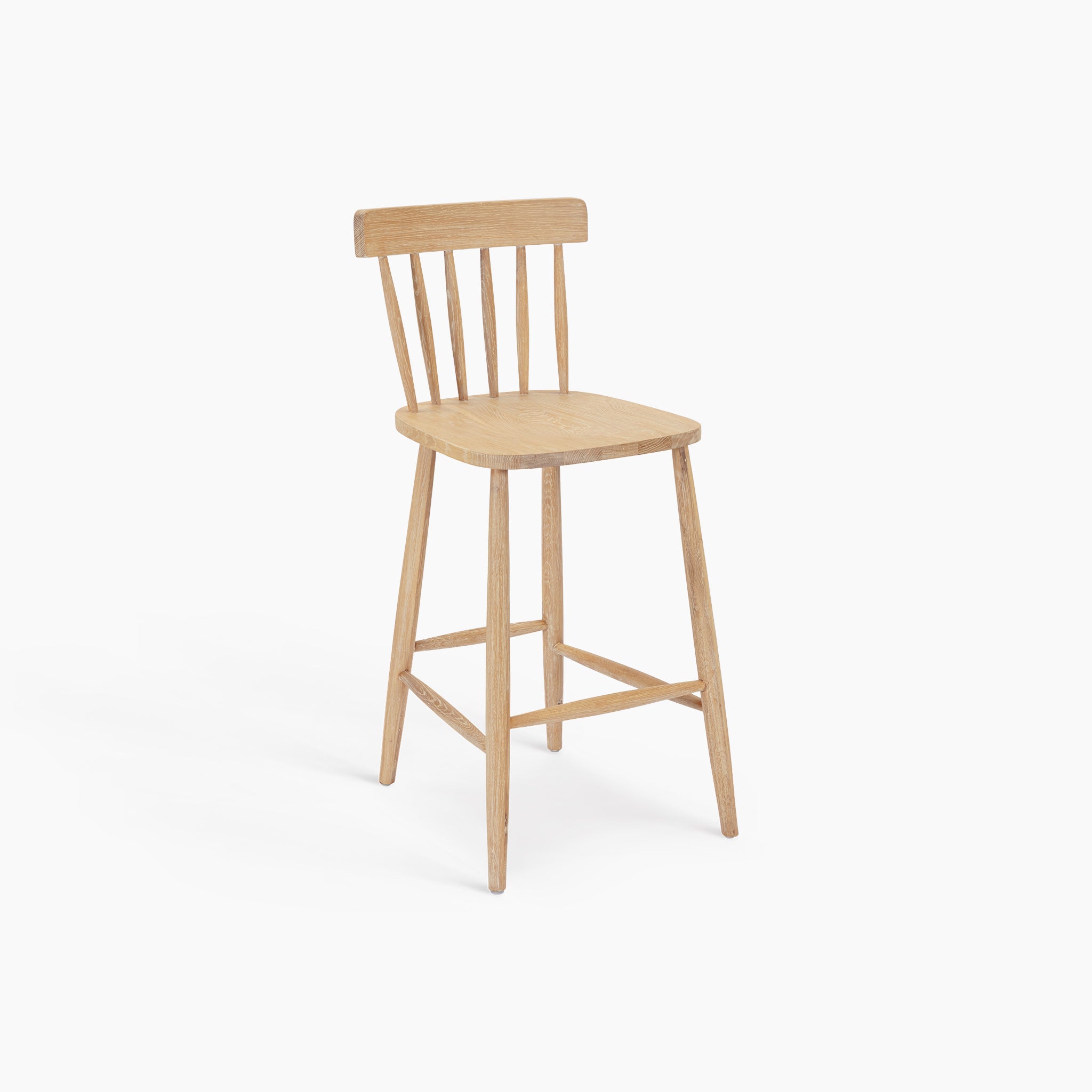 The Burford Spindleback Bar Stool in Natural Oak is a light wooden kitchen island stool with a slatted backrest and four legs, shown here on a white background.
