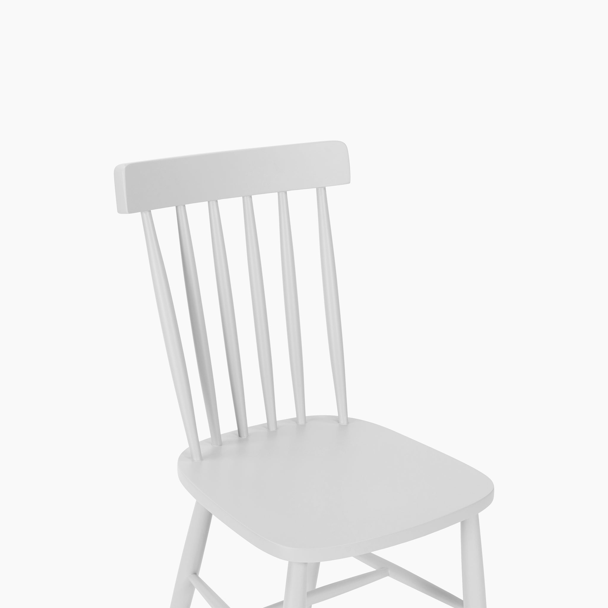 The Burford Set of 2 Spindleback Dining Chairs in Warm White features vertical slats on the backrest, offering a classic touch to any country-style dining space.