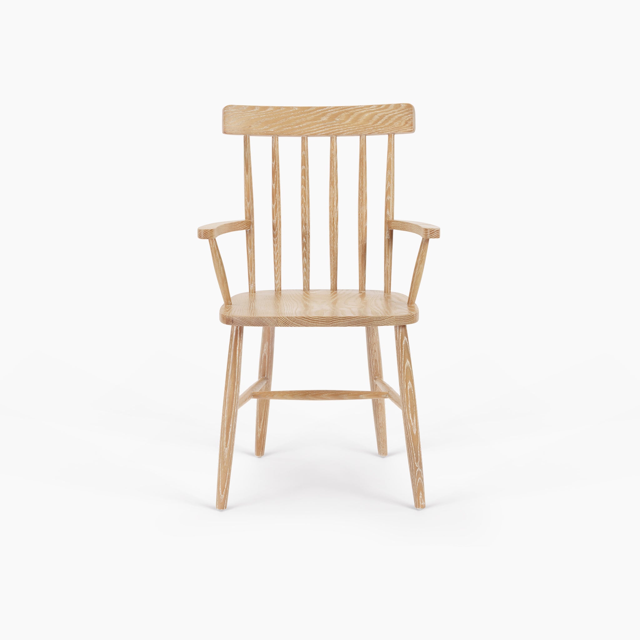 The Burford Spindleback Dining Chair with Armrest in Natural Oak features vertical backrest slats, a light oak finish, armrests, and four angled legs, shown on a white background.