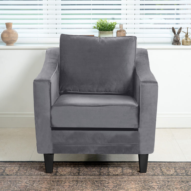 The Wiltshire Velvet Armchair in Steel Grey adds elegance with sustainable birch and beech wood. Stylish and eco-friendly, it fits perfectly in a room featuring a window, pottery, and a rug, making it an ideal addition to any contemporary living space.