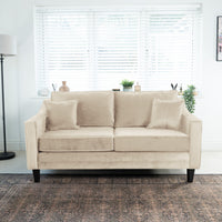 The Wiltshire 2 Seat Velvet Sofa in Cream sits elegantly in the bright room, complemented by a floor lamp and window blinds.
