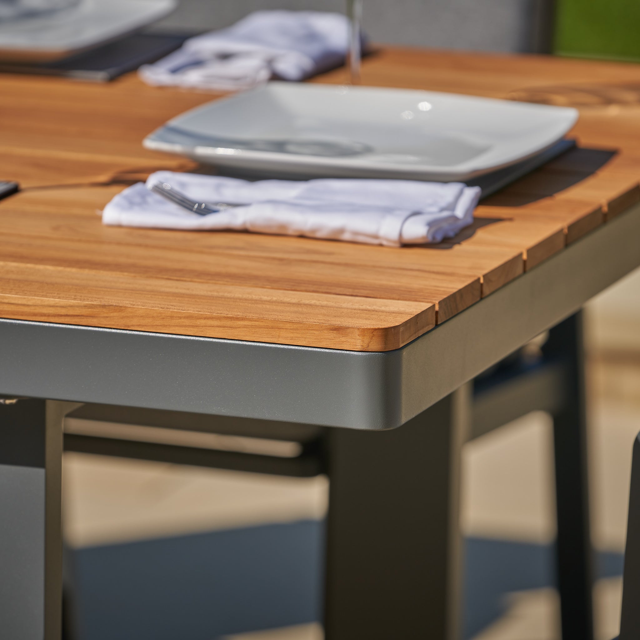 The Pacific Lifestyle - Stockholm 6 Seat Rectangular Dining Set in Marl Grey is exquisitely set with plates, napkins, and silverware under the sun, featuring weatherproof dining chairs for lasting comfort and style.