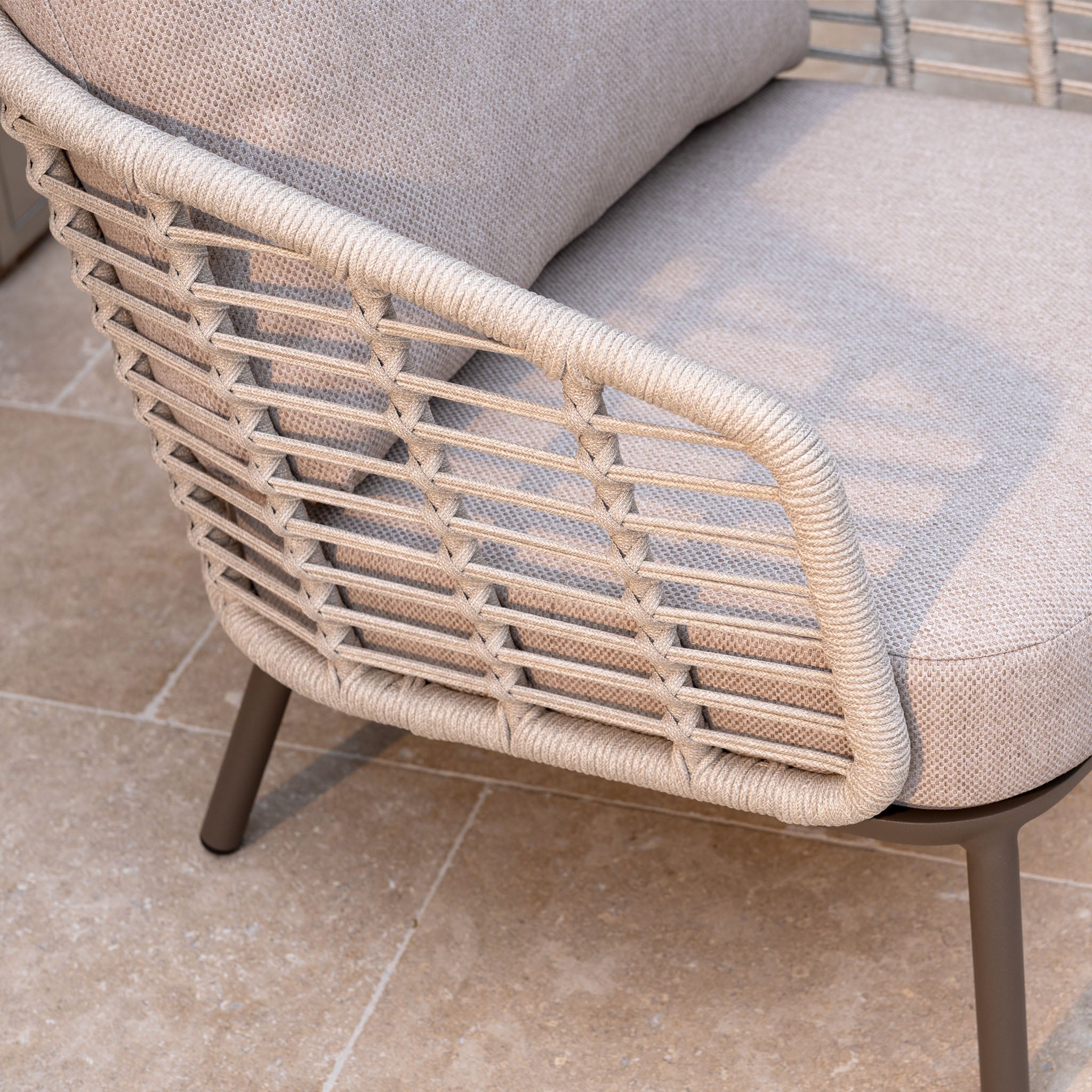 The Sutera 3 Seat Sofa Set in Putty features woven rope backrests and all-weather cushions, making it ideal for enhancing your garden furniture ensemble on a stone tile floor.
