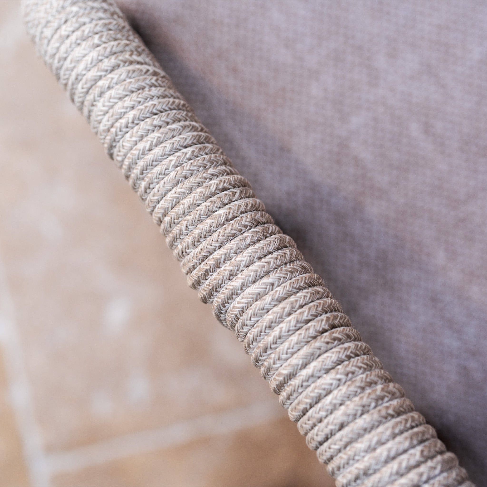 Close-up of a textured woven rope handle on the Sutera 3 Seat Sofa Set in Putty, showcasing quality craftsmanship—ideal for elevating your outdoor space. Blurred background adds depth.