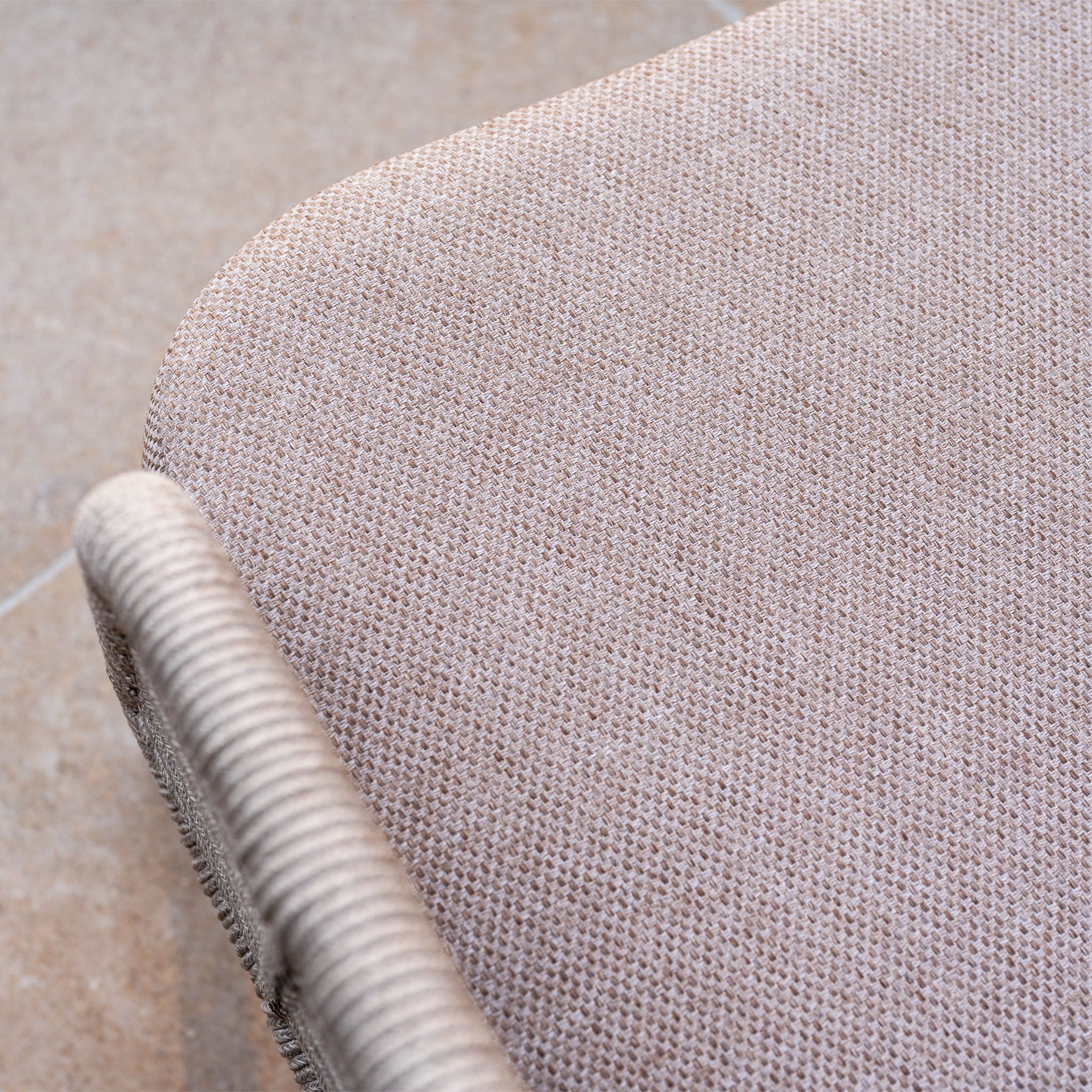 Close-up of the textured seat and curved armrest of the Sutera 3 Seat Sofa Set in Putty, displayed on a tiled floor.