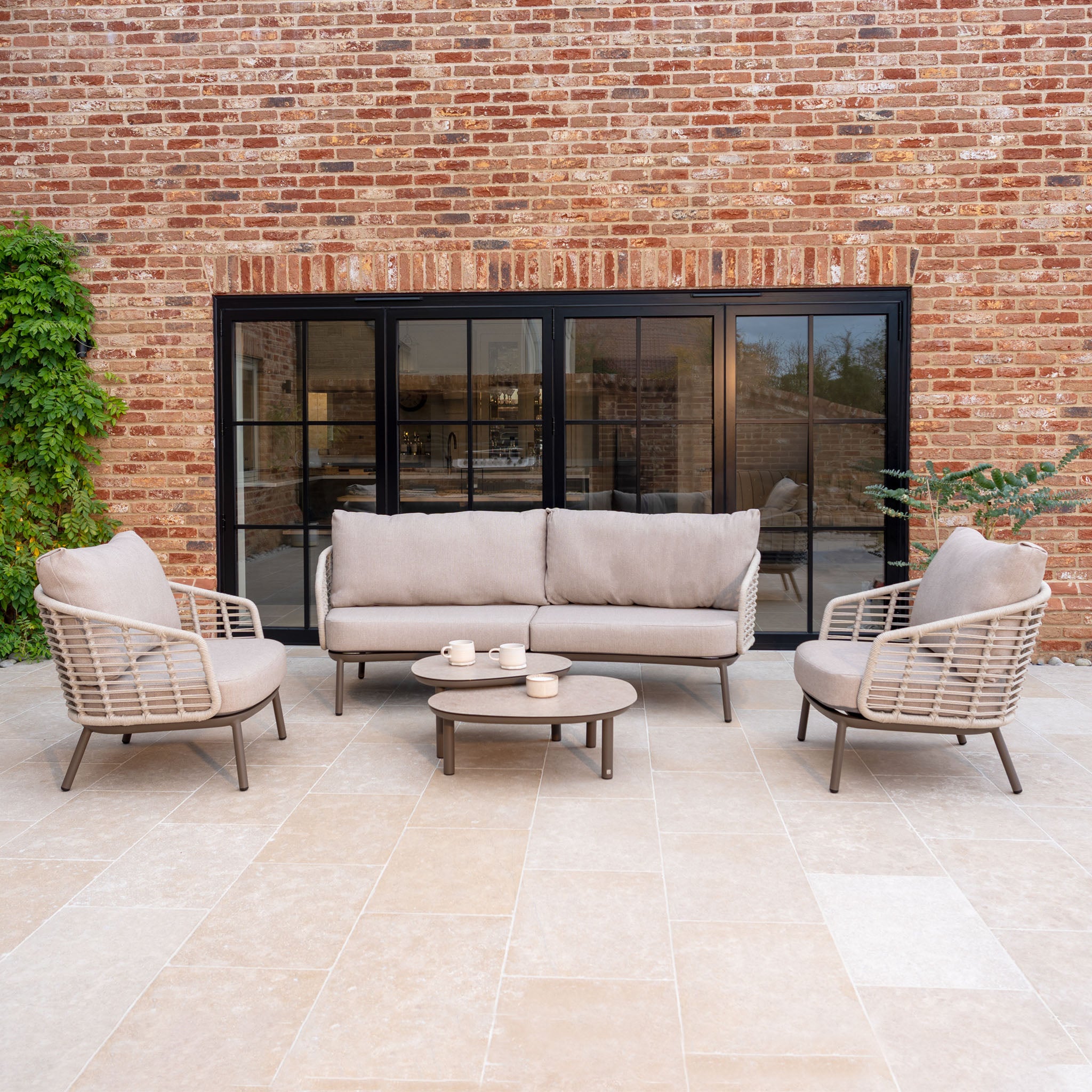 Enjoy effortless outdoor living with the Sutera 3 Seat Sofa Set in Putty, featuring a sofa, two chairs, and a coffee table with all-weather cushions for comfort and style on your patio.