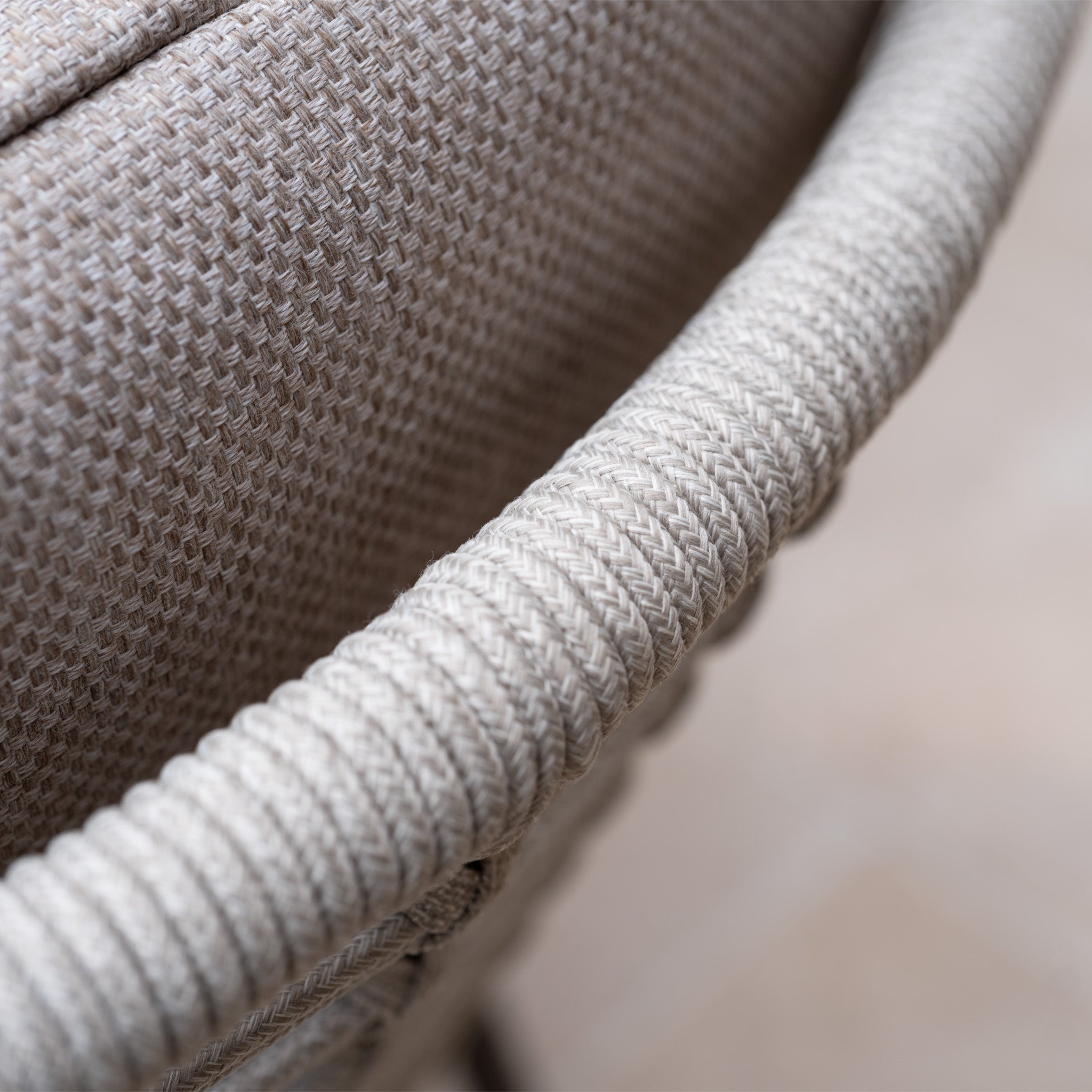 Close-up of the woven fabric backrest and armrest in beige tones from the Sutera 6 Seat Curved Rectangular Dining Set in Putty, designed for outdoor use.