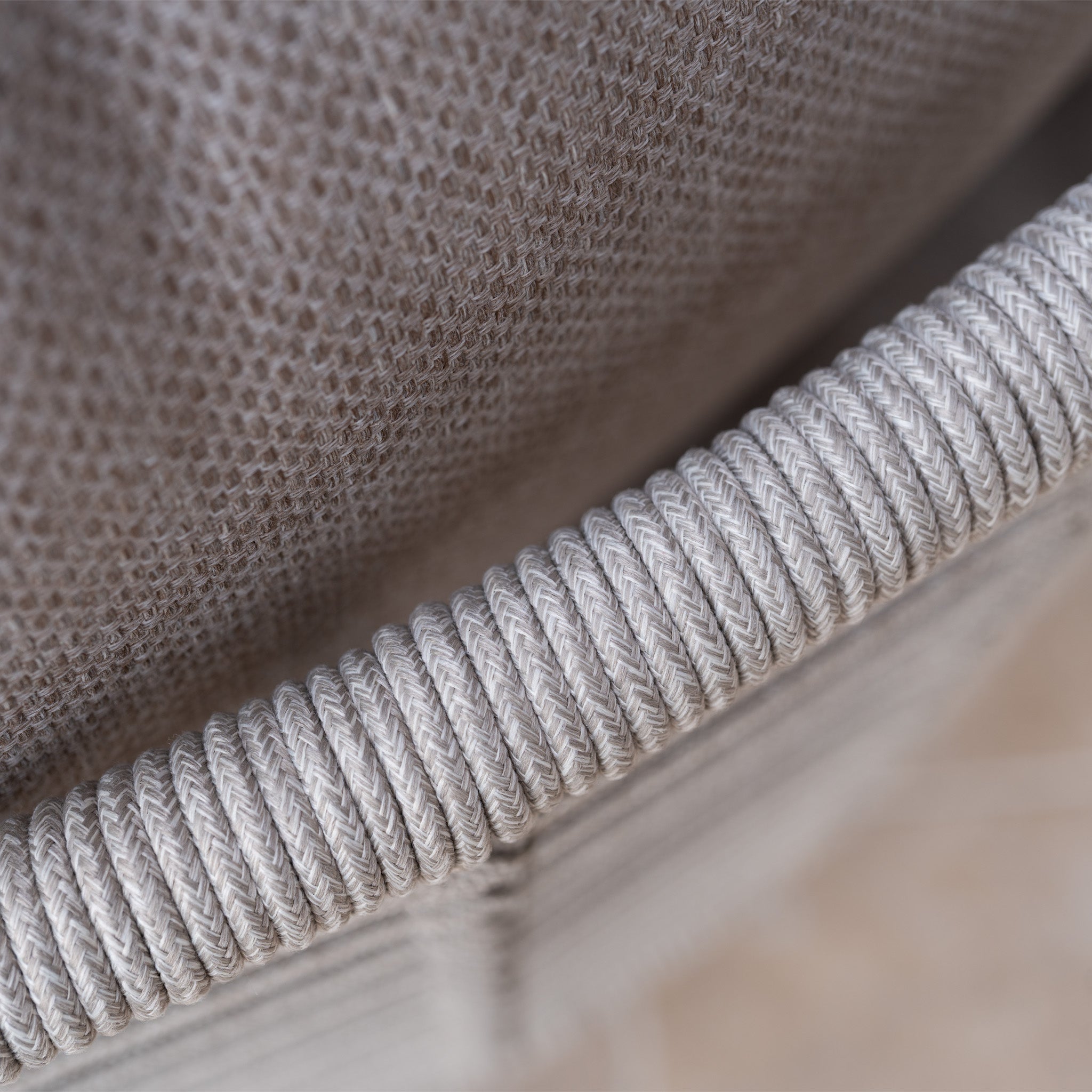 Close-up of the textured putty gray fabric and tightly wrapped woven rope detail on the Sutera Curved Chaise Sofa Set in Putty.