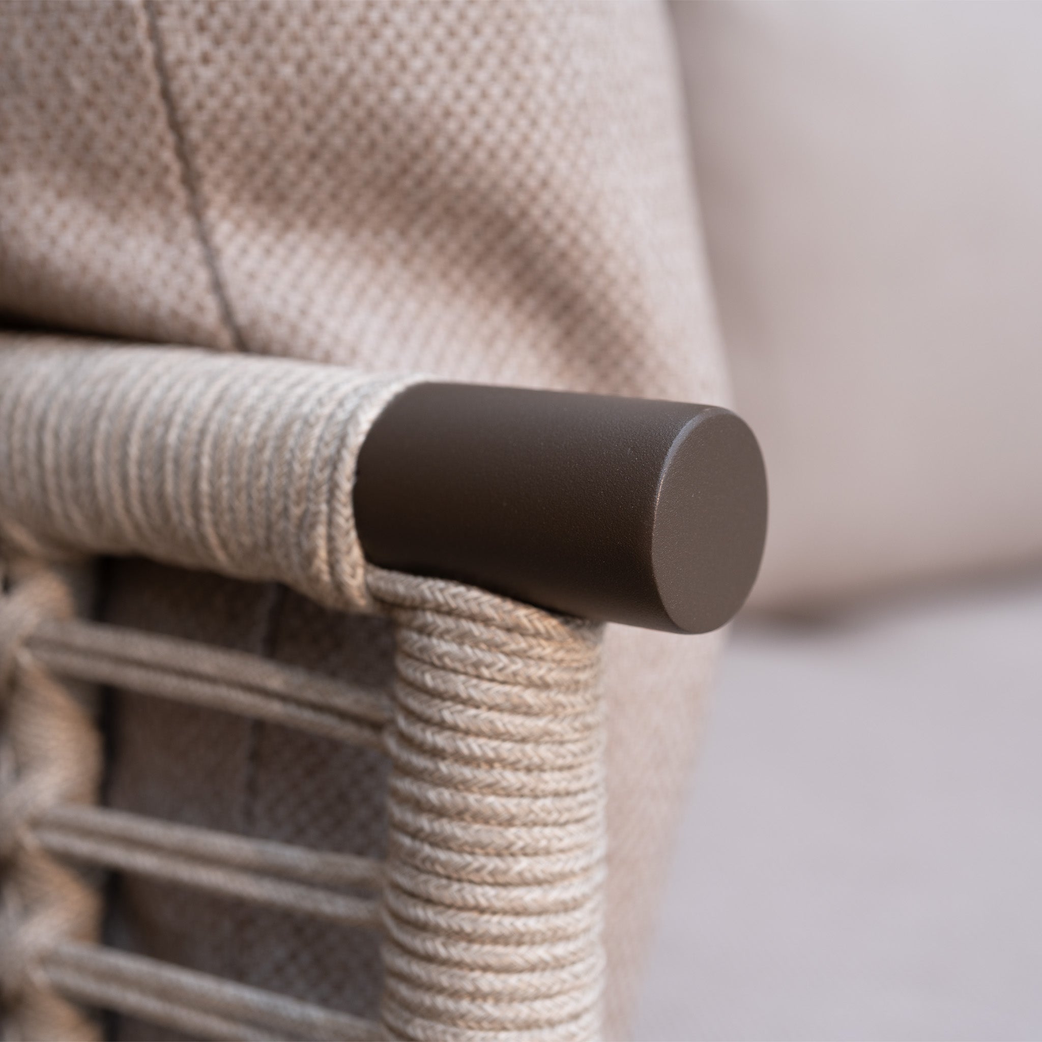 Close-up of a metal armrest wrapped with rope on the Sutera Curved Chaise Sofa Set with Armchair in Putty, featuring all-weather cushions and beige upholstery—ideal outdoor garden furniture for lasting comfort.