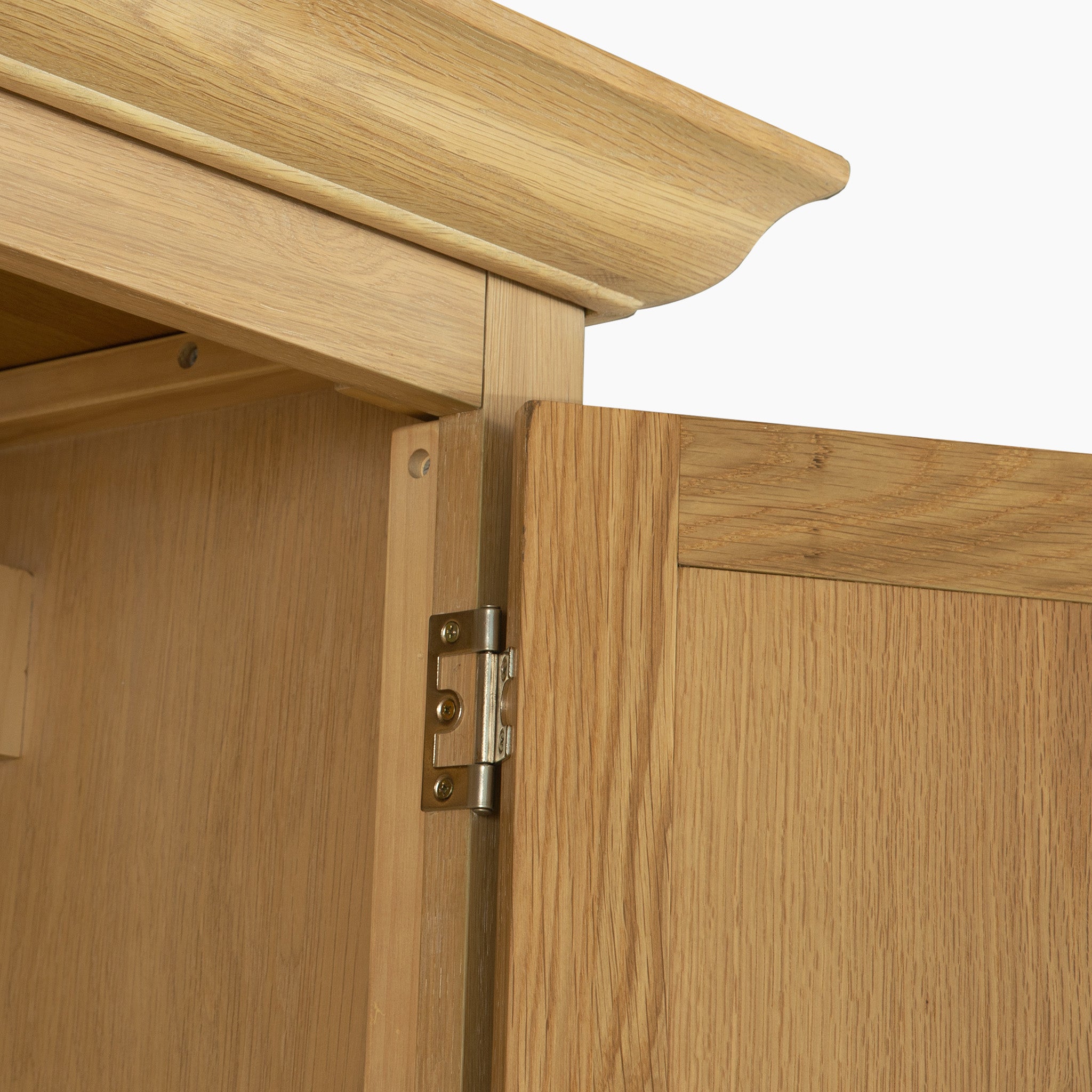 Close-up of the Amberley Double Wardrobe in Light Oak, showcasing hinge details and stunning wood grain—a refined feature for solid oak bedroom furniture.