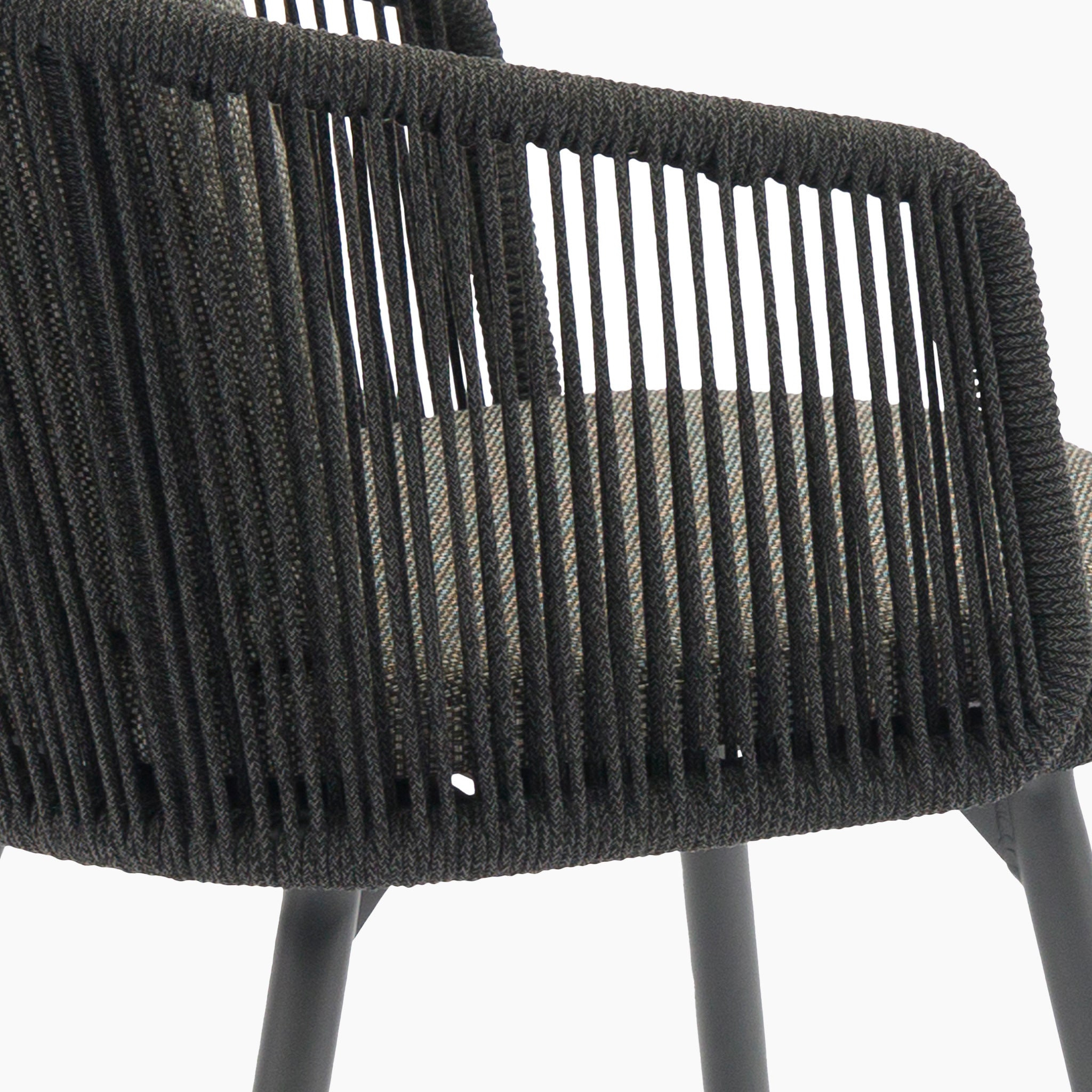 Close-up of a modern chair from the Dekota 6 Seat Rope Dining Set with Albatross Extending Table in Charcoal, featuring a woven black rope backrest and cushioned gray seat.