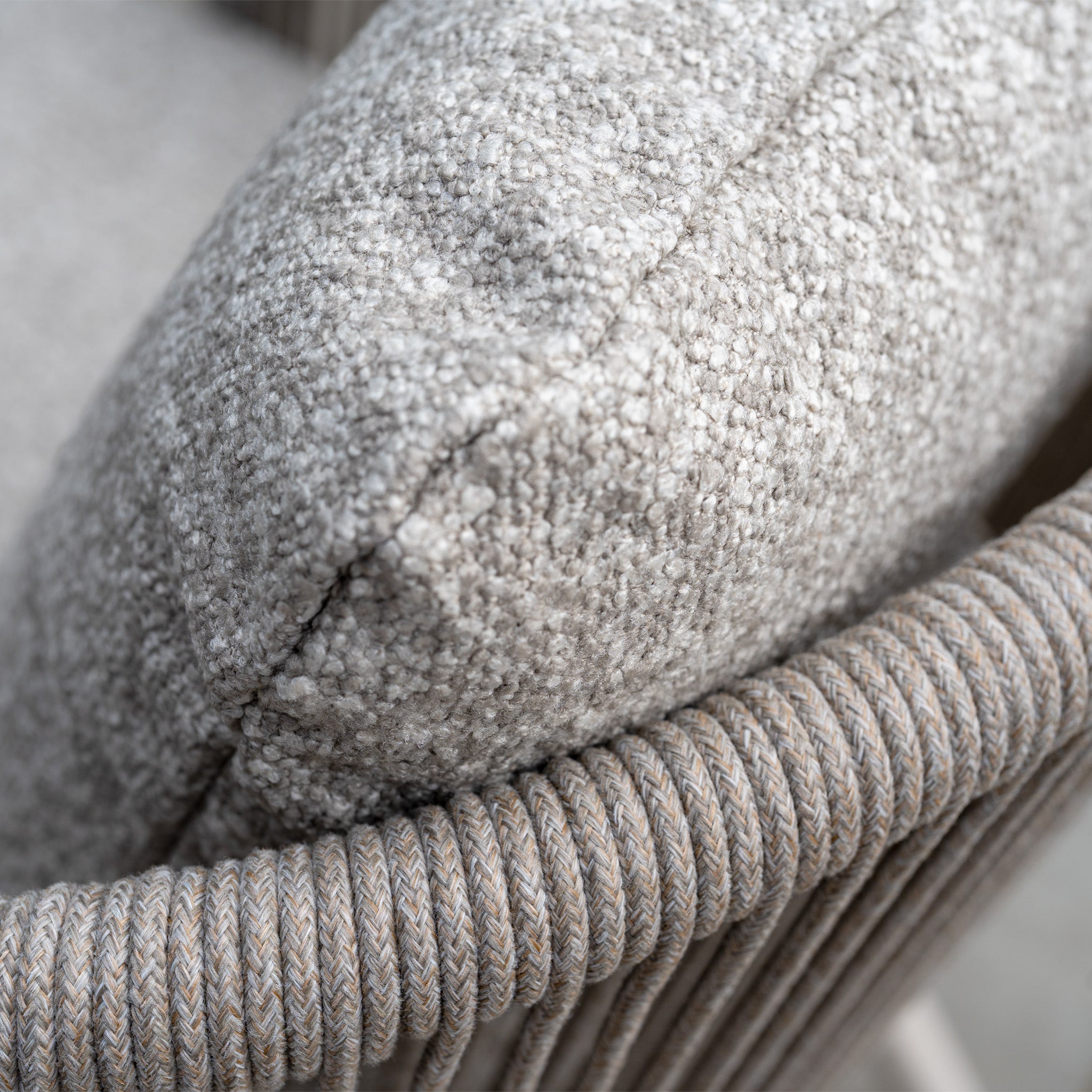 Close-up of a textured beige cushion on a woven rope chair from the Theia 8 Seat Rope Dining Set with Albatross Extending Table in Oatmeal.