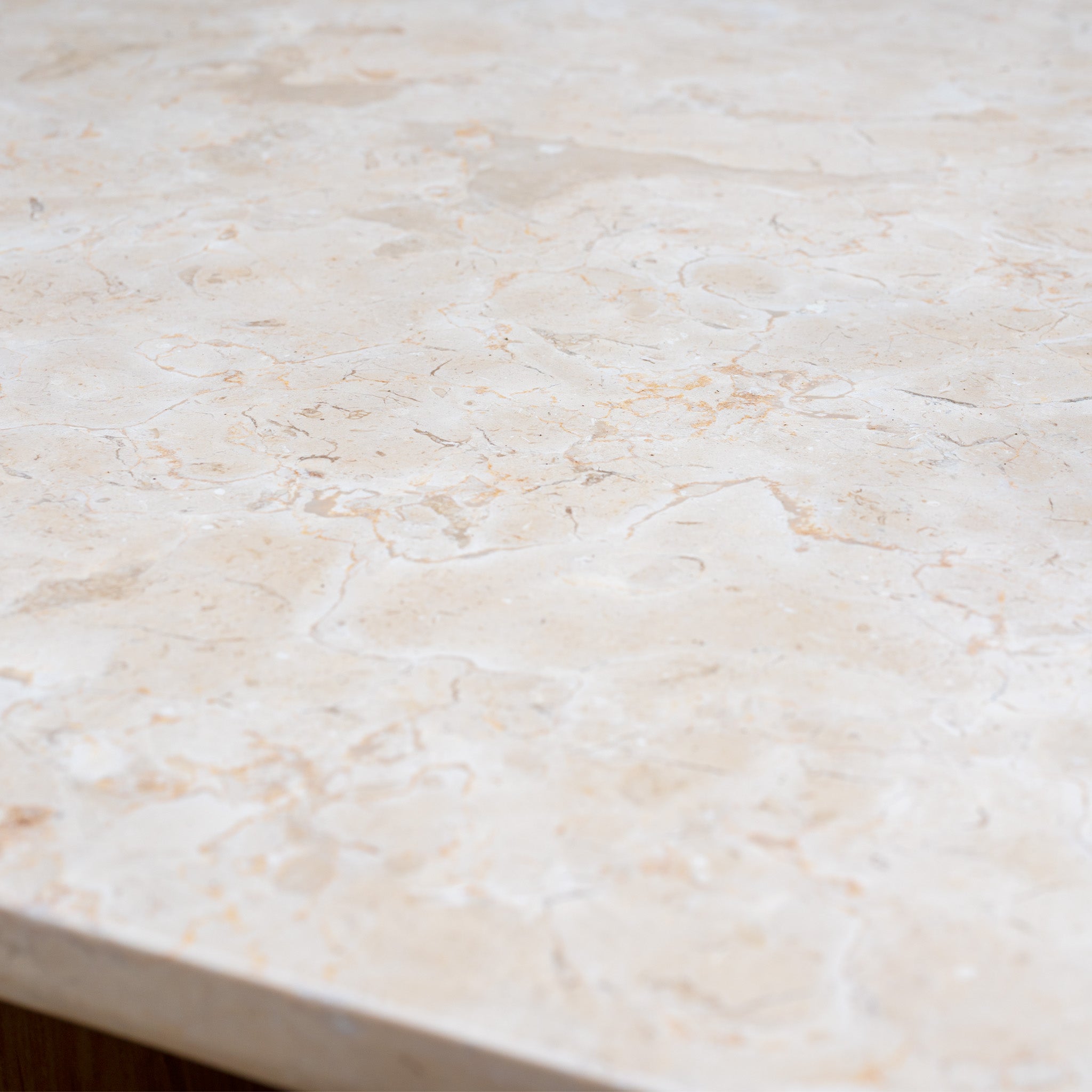 Close-up of a light beige marble countertop with natural veining and subtle patterns, perfect for pairing with the Tivoli 3 Seat Sofa Set with Marble Coffee Table in Fawn.