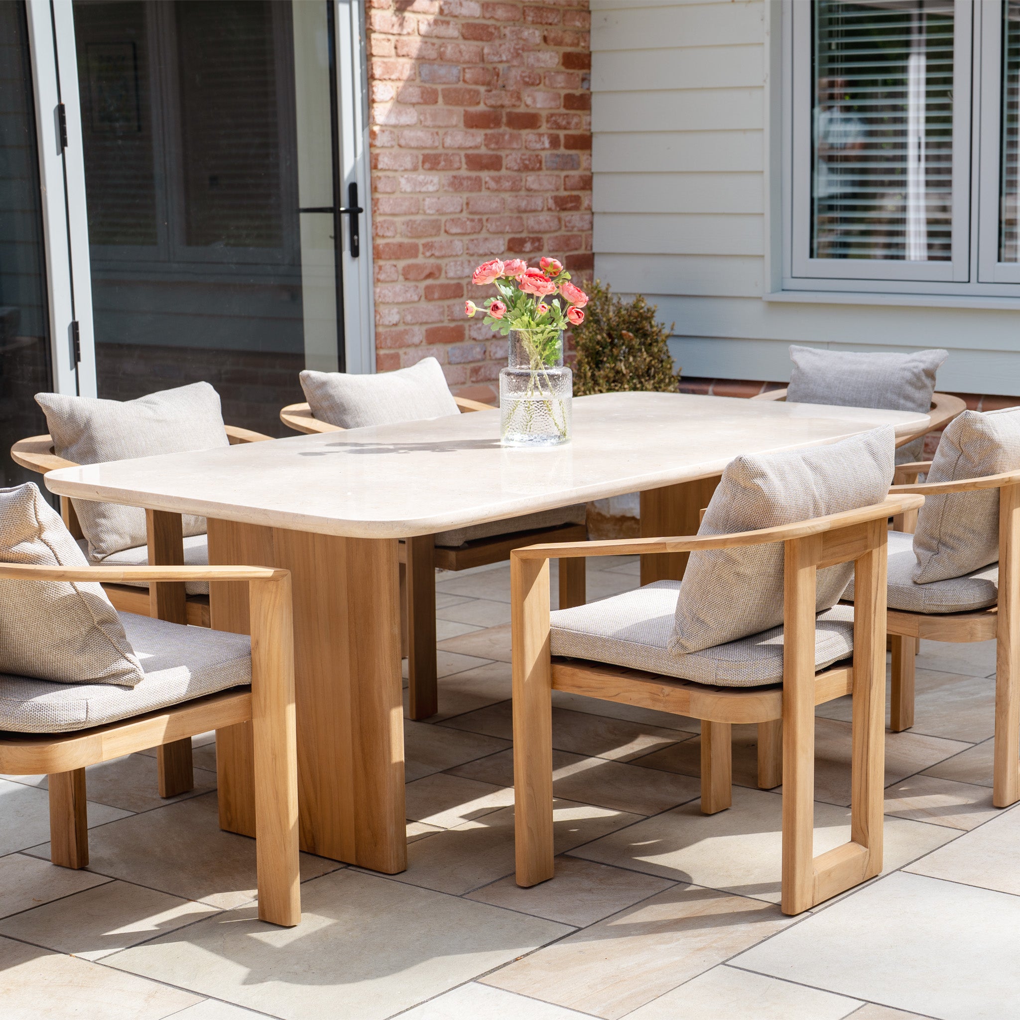The Tivoli 6 Seat Dining Set features a marble dining table in fawn and six cushioned chairs, exuding modest luxury and style.