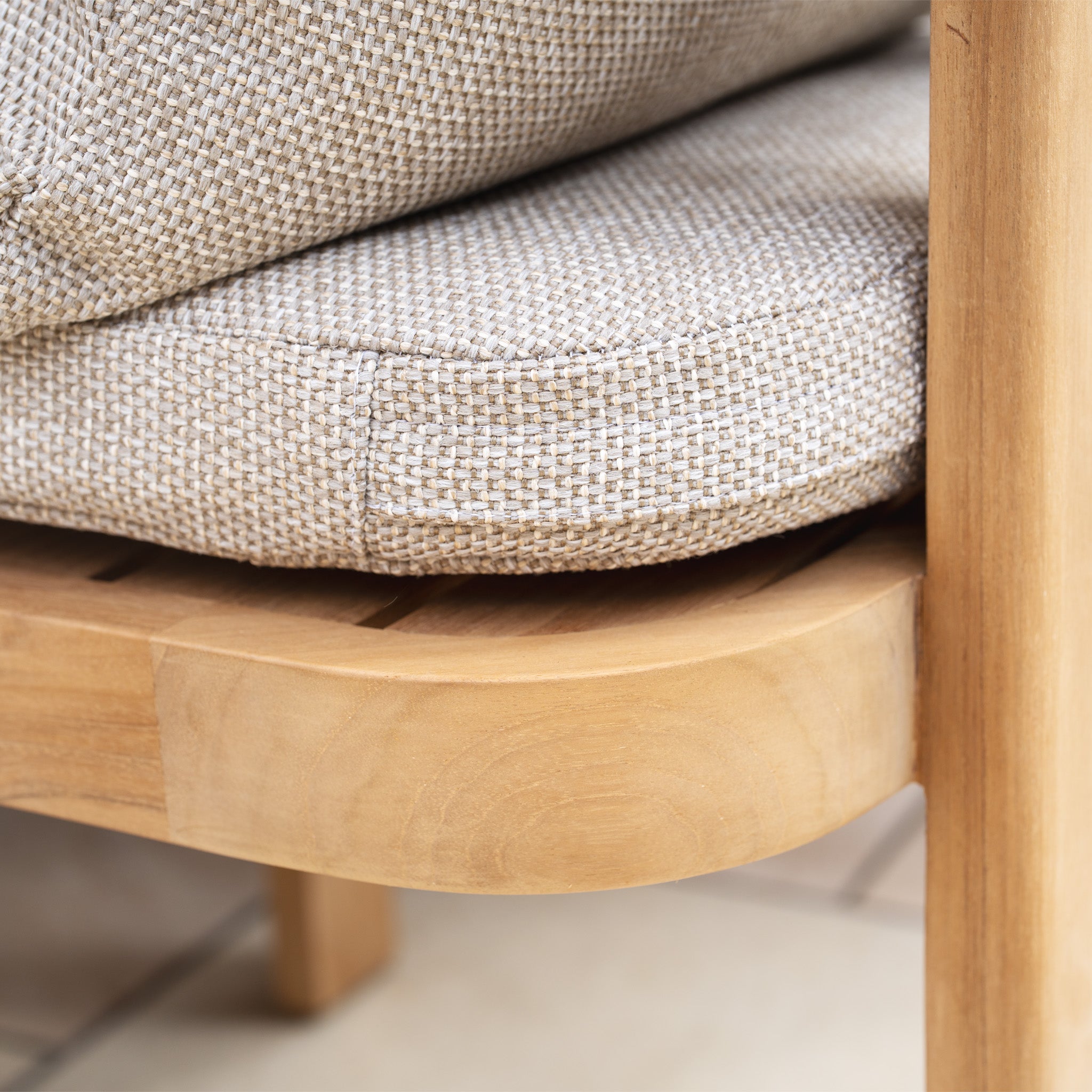 Close-up of a beige woven cushion on a light wooden chair with a smooth, rounded edge, perfectly complementing the elegance of the Tivoli 6 Seat Dining Set with Marble Dining Table in Fawn.