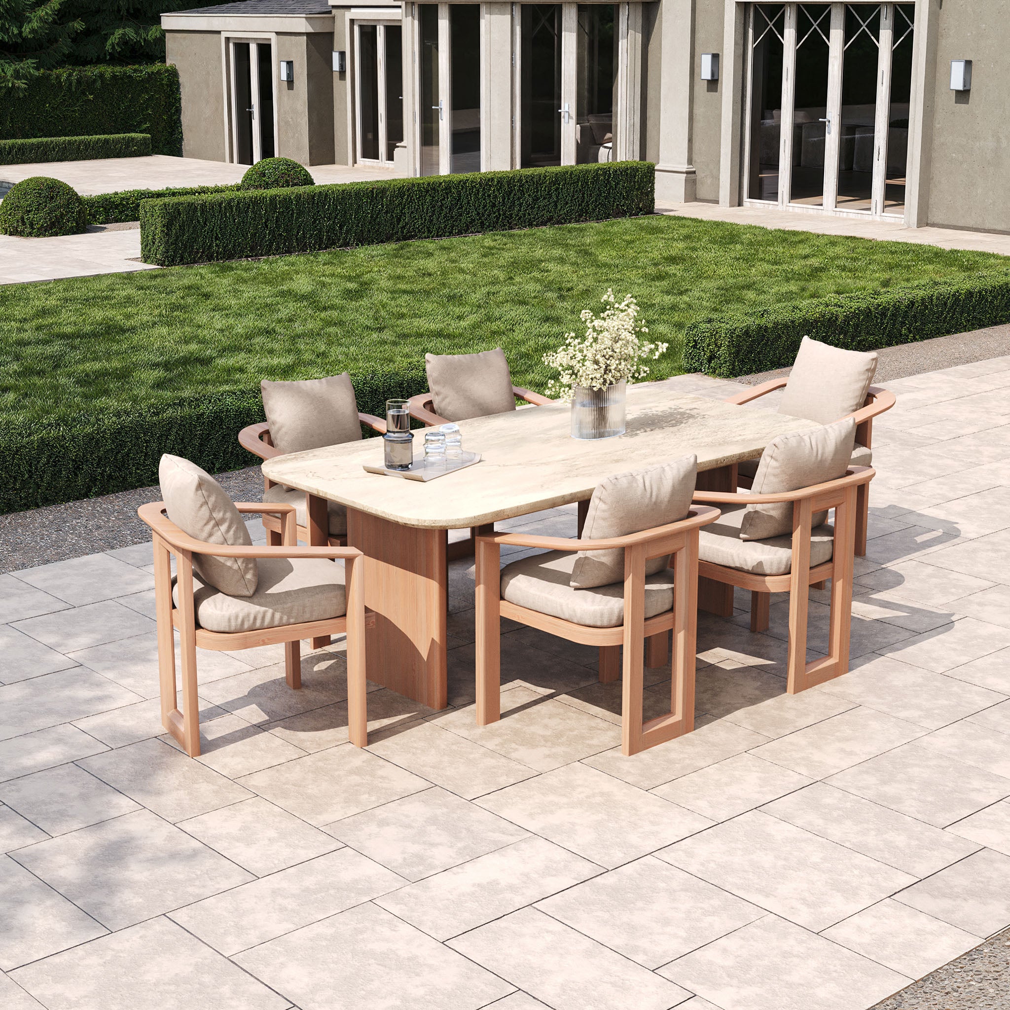 The Tivoli 6 Seat Dining Set with Marble Dining Table in Fawn includes six cushioned chairs on a tiled patio amidst greenery, elegantly accentuated by a central vase of flowers.