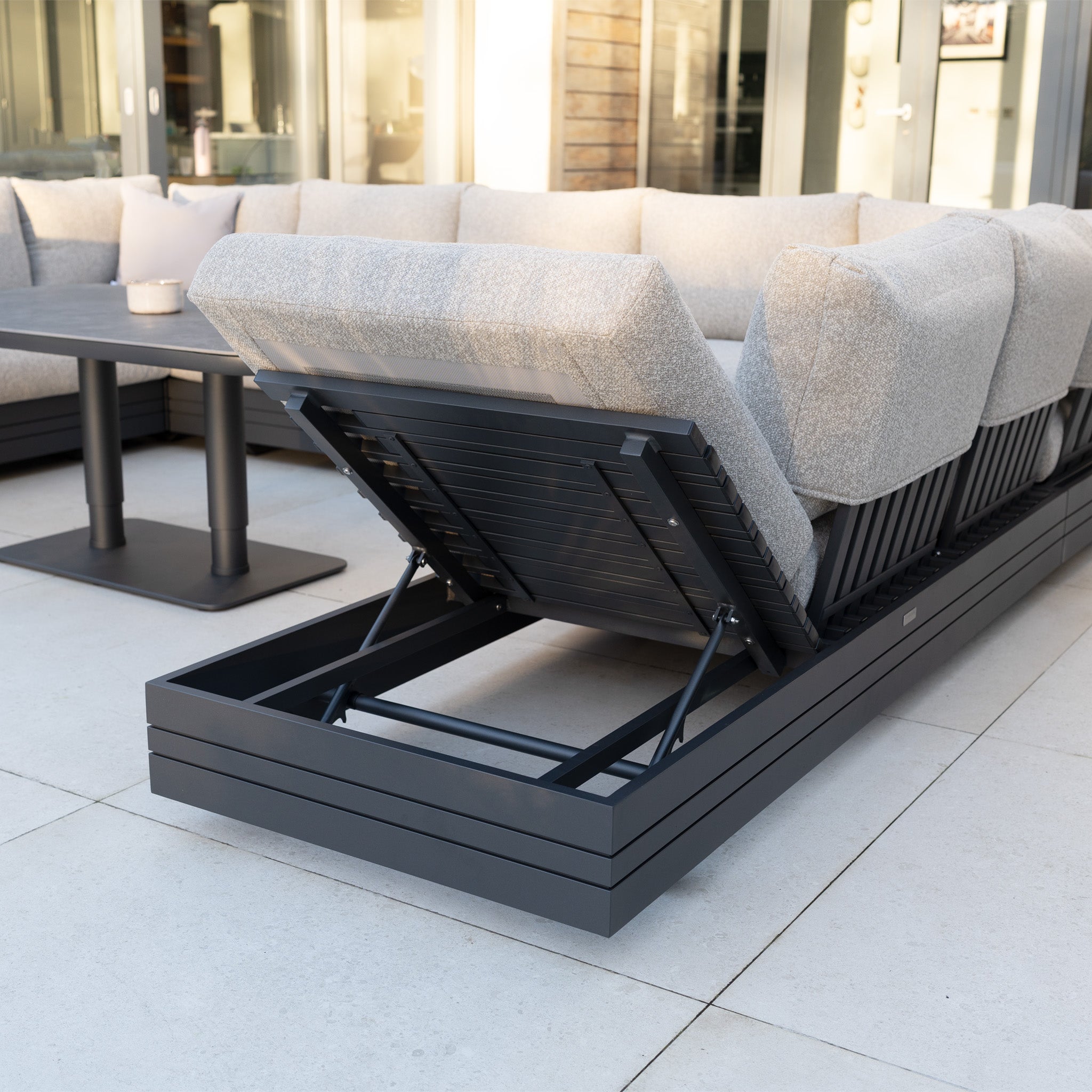 The Savona Luxury Outdoor Large U-Shape Corner Sofa Set with Altura Rising Table in Truffle offers modular garden seating, an adjustable chaise, and a rust-proof aluminium frame with stylish dark metal accents.