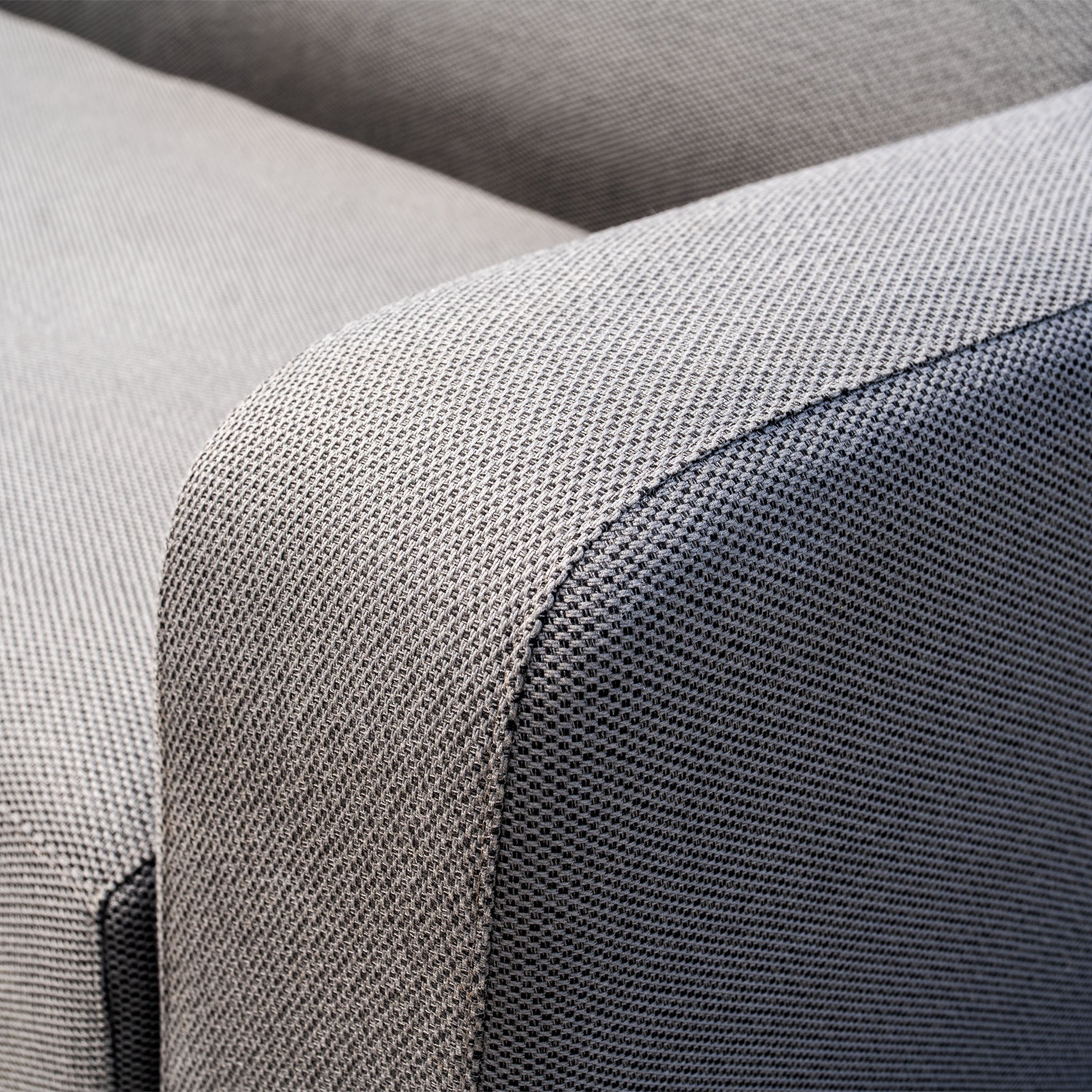 Close-up of the Luna Outdoor Fabric Corner Sofa Set with Coffee Table in Grey, featuring stain-proof, textured fabric and curved armrests.