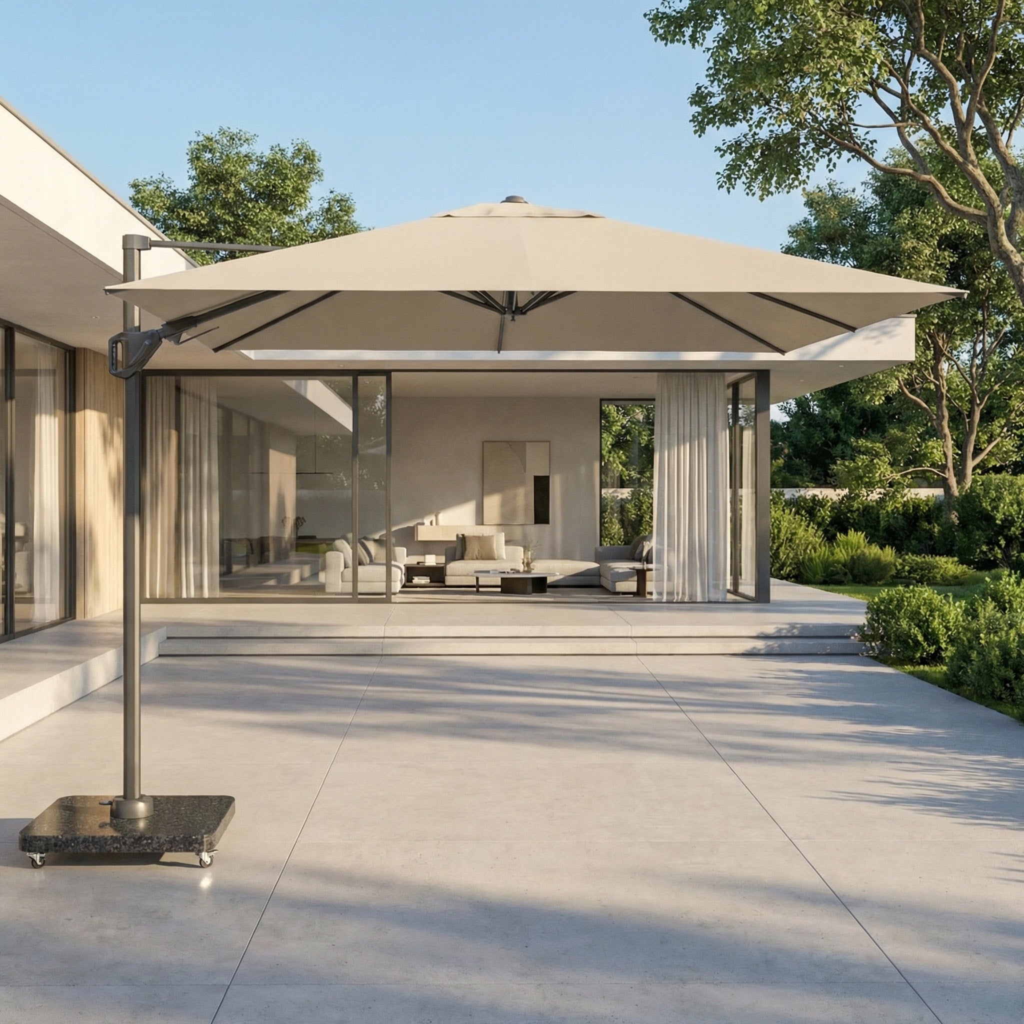 The Voyager T2 2.7m Square Cantilever Parasol in Champagne, with UV protection, shades a modern outdoor seating area by a glass-walled house surrounded by lush greenery.