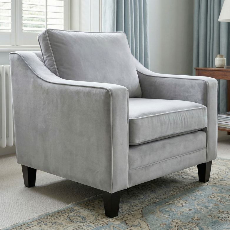 Wiltshire Velvet Armchair in Feather Grey with dark wooden legs is featured in a bright, modern living room.