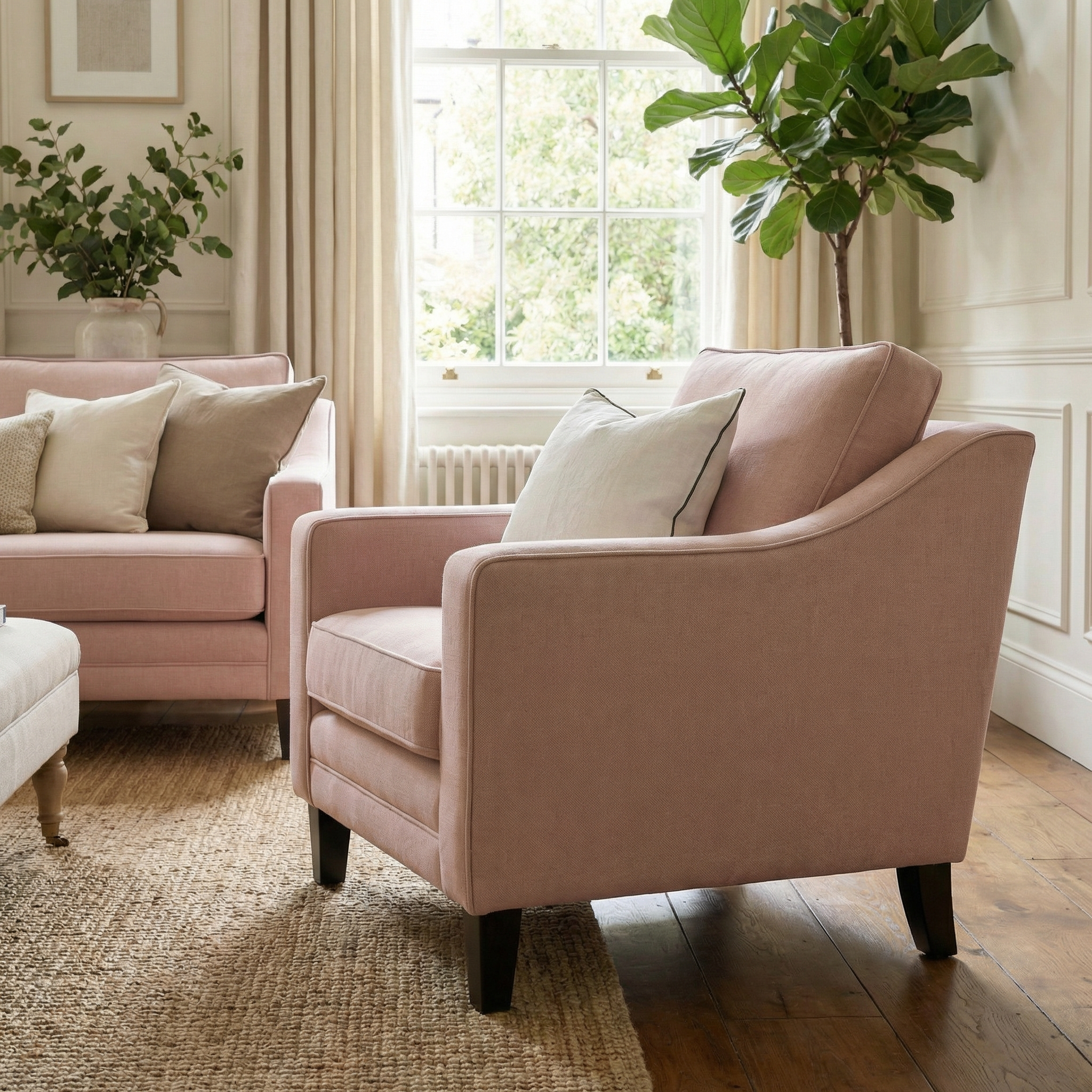 The Wiltshire Armchair in Dusky Pink brings charm to a bright, cozy living room with lush plants, a sunlit window, and neutral decor.