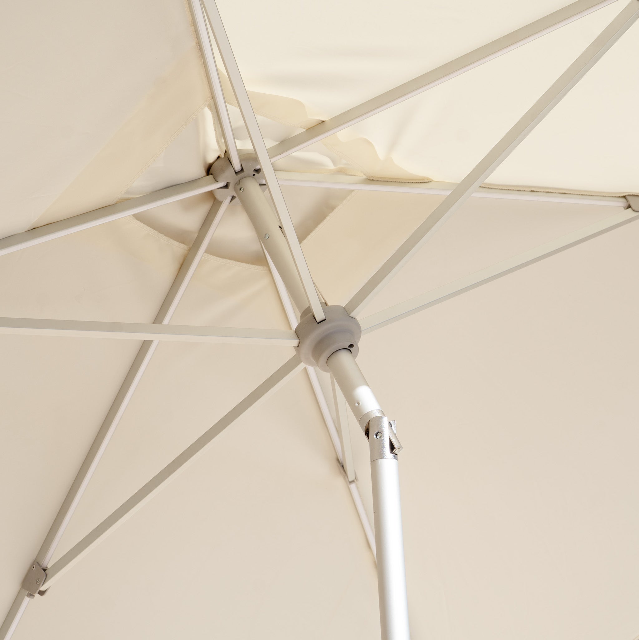 Beneath the Zelos 3m x 2m Rectangular Parasol with LED Lighting in Cream, marvel at its sturdy metal frame and spokes, providing UV protection on sunny days.