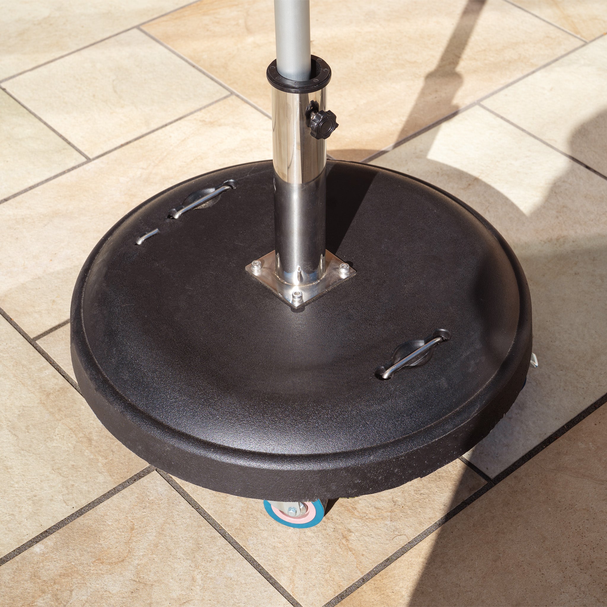 A Zelos 2.5m Square Parasol with LED Lighting in Green, featuring a base with wheels, rests on a tiled floor, casting a shadow in the outdoor space.