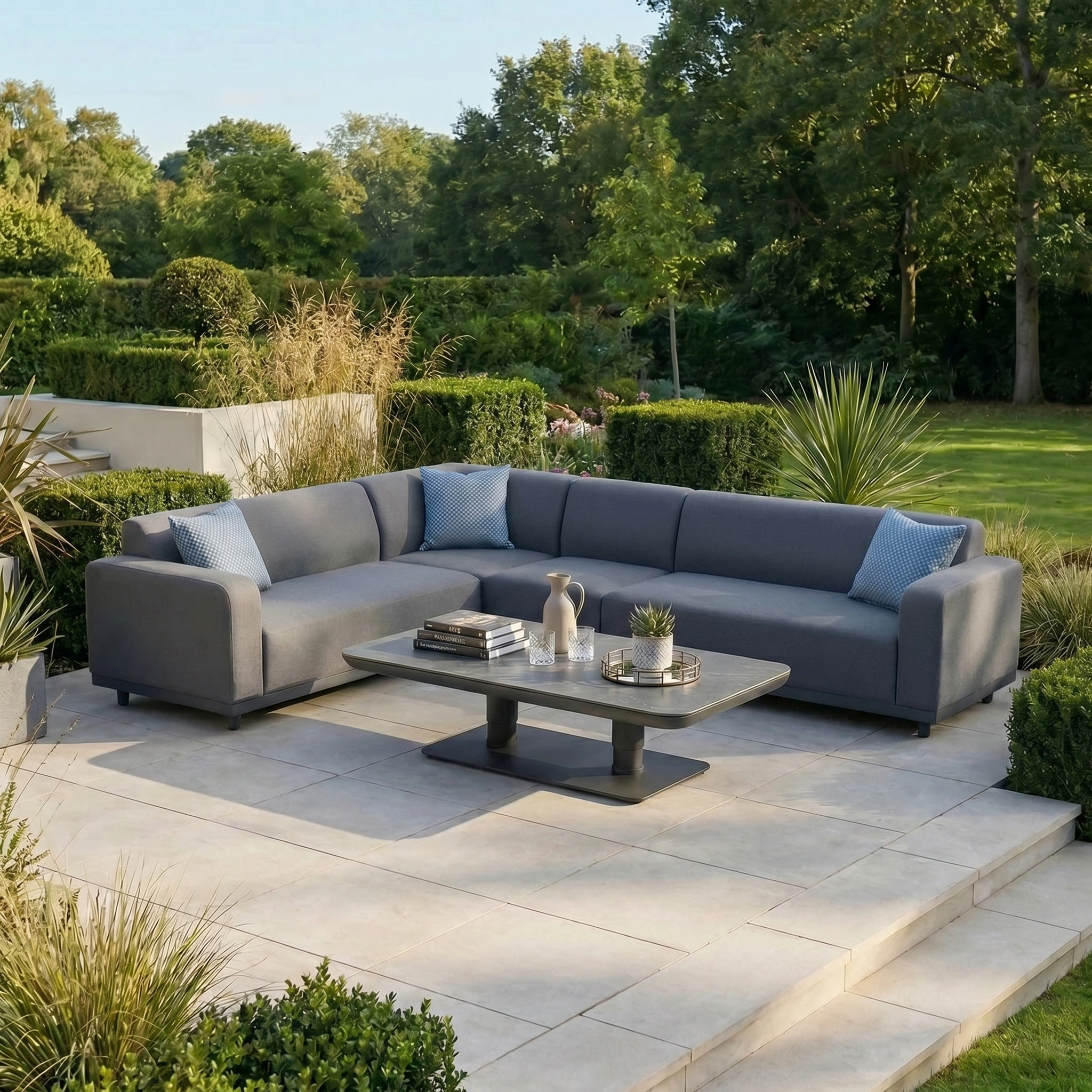 A grey sectional outdoor sofa features Agora Senda Blue Medium Scatter Cushions (45cm x 45cm), made from solution-dyed acrylic, and is placed on a patio beside a coffee table.