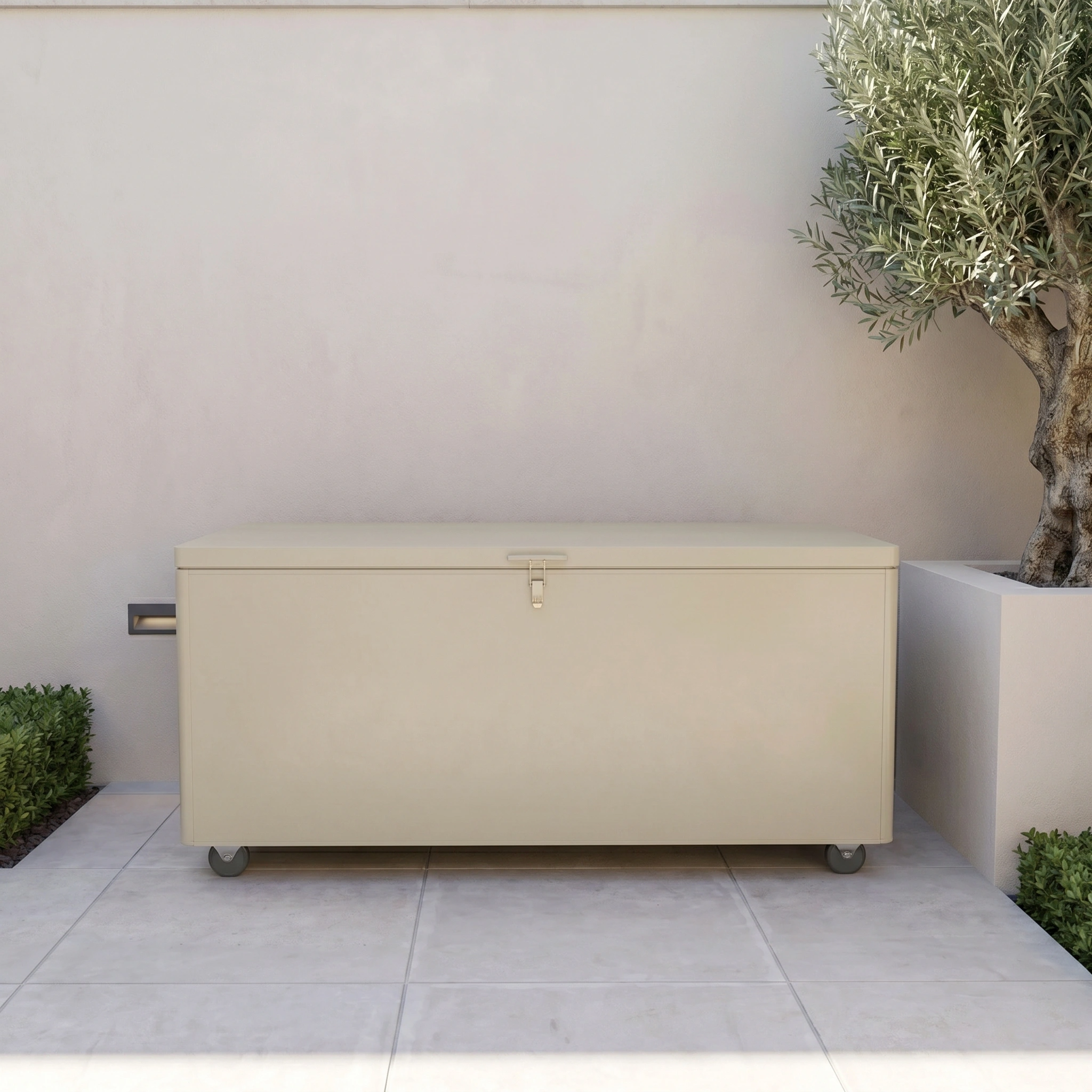 Large Aluminium Storage Box in Latte with wheels, placed on a tiled patio beside a potted tree and shrub.