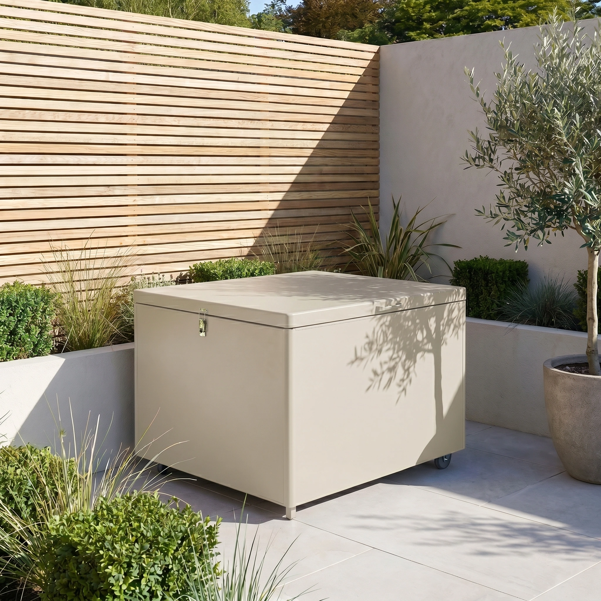 Small Aluminium Storage Box in Latte placed on a tiled patio, surrounded by green plants and wooden fencing.