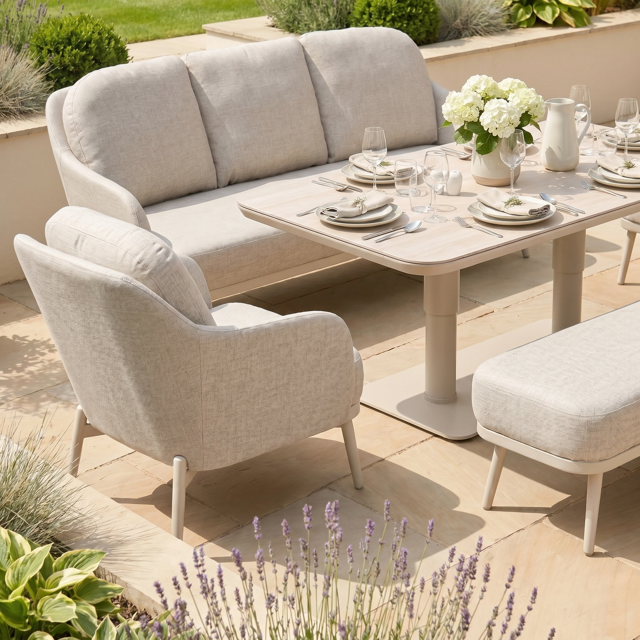 The Alva 3 Seat Sofa Dining Set with Rising Table in Fawn is an outdoor garden ensemble featuring a sofa, armchair, bench, and table ideal for dining.
