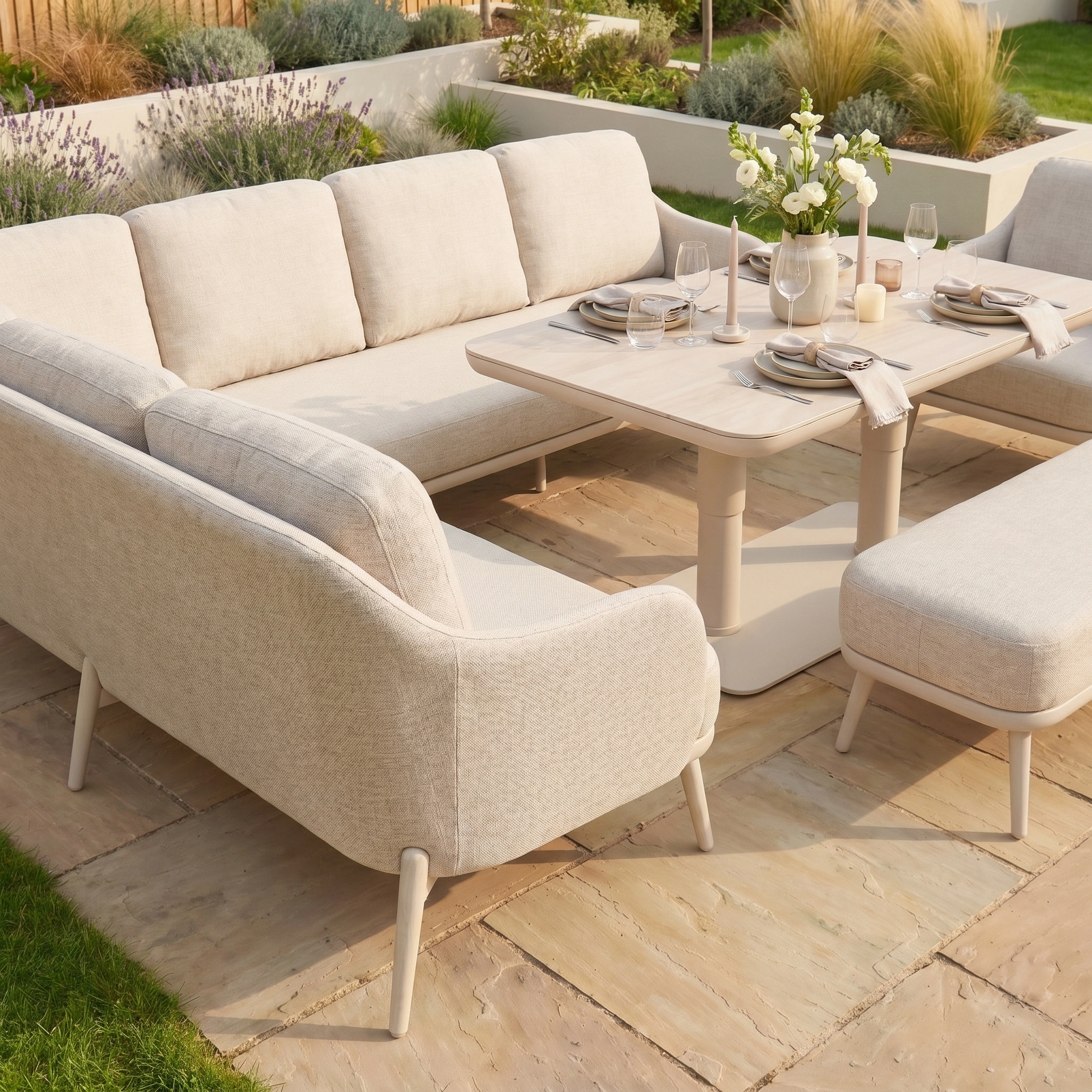Alva Corner Dining Set with Rising Table and Armchair in Fawn, featuring cream-colored cushions and surrounded by decorative plants, offers stylish outdoor patio seating for four.