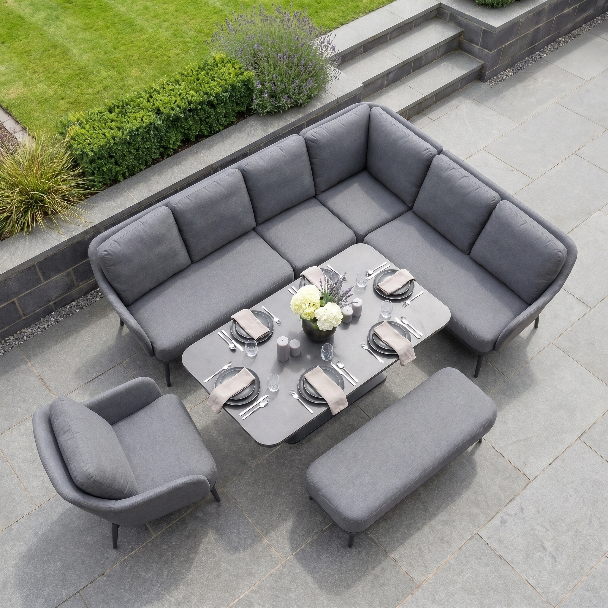 The Alva Corner Dining Set with Rising Table and Armchair in Grey features sleek cushions and a versatile table—ideal garden furniture for stylish outdoor gatherings on your patio or terrace.