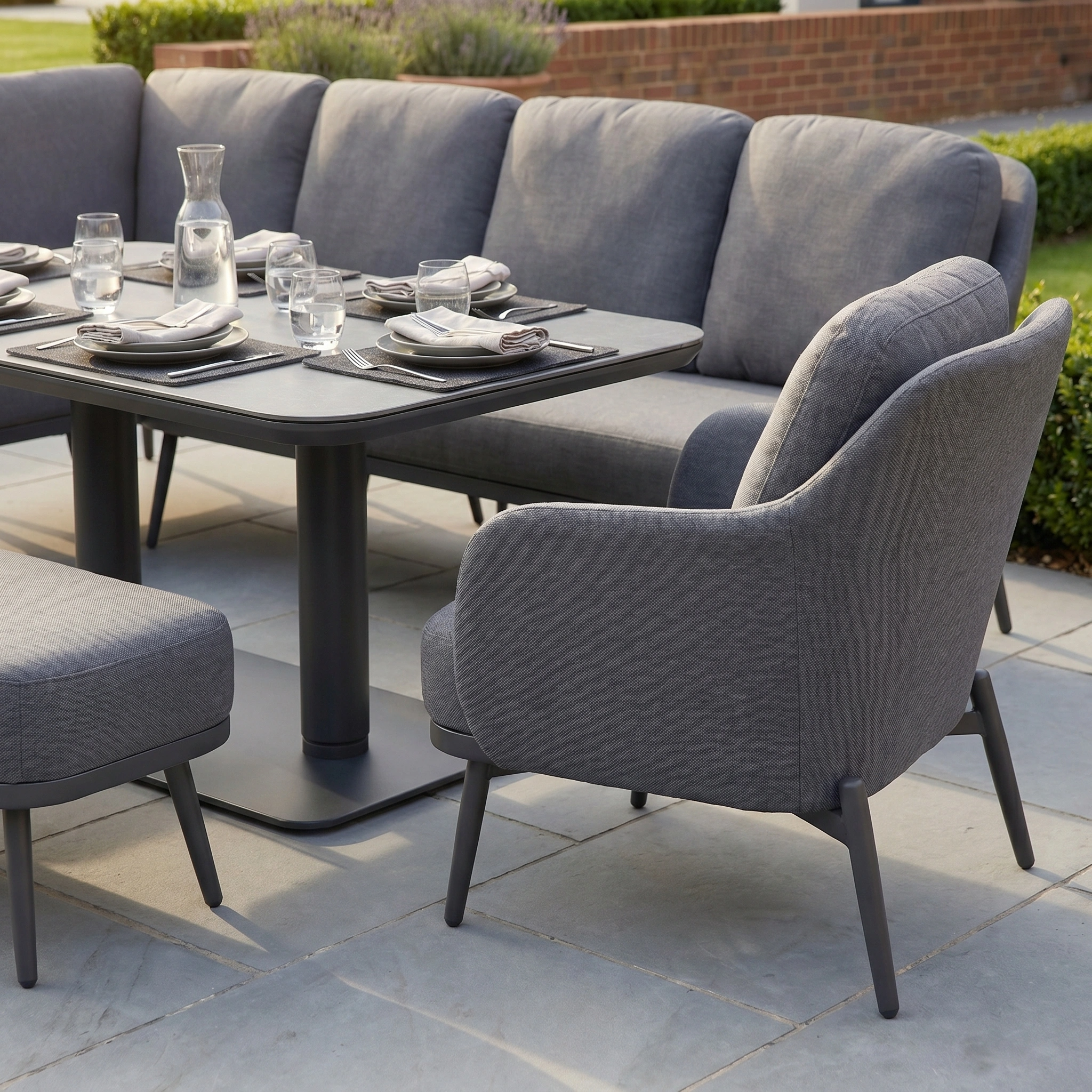 Alva Corner Dining Set with Rising Table and Armchair in Grey, featuring a corner dining arrangement and ottoman, perfect for outdoor patio use.