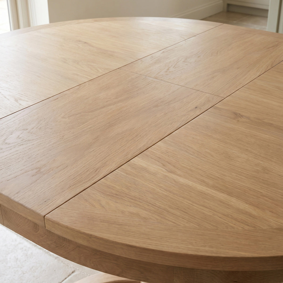 Close-up of the Amberley 4-6 Seater Round Extending Dining Table in Light Oak, showing its center seam and grain.