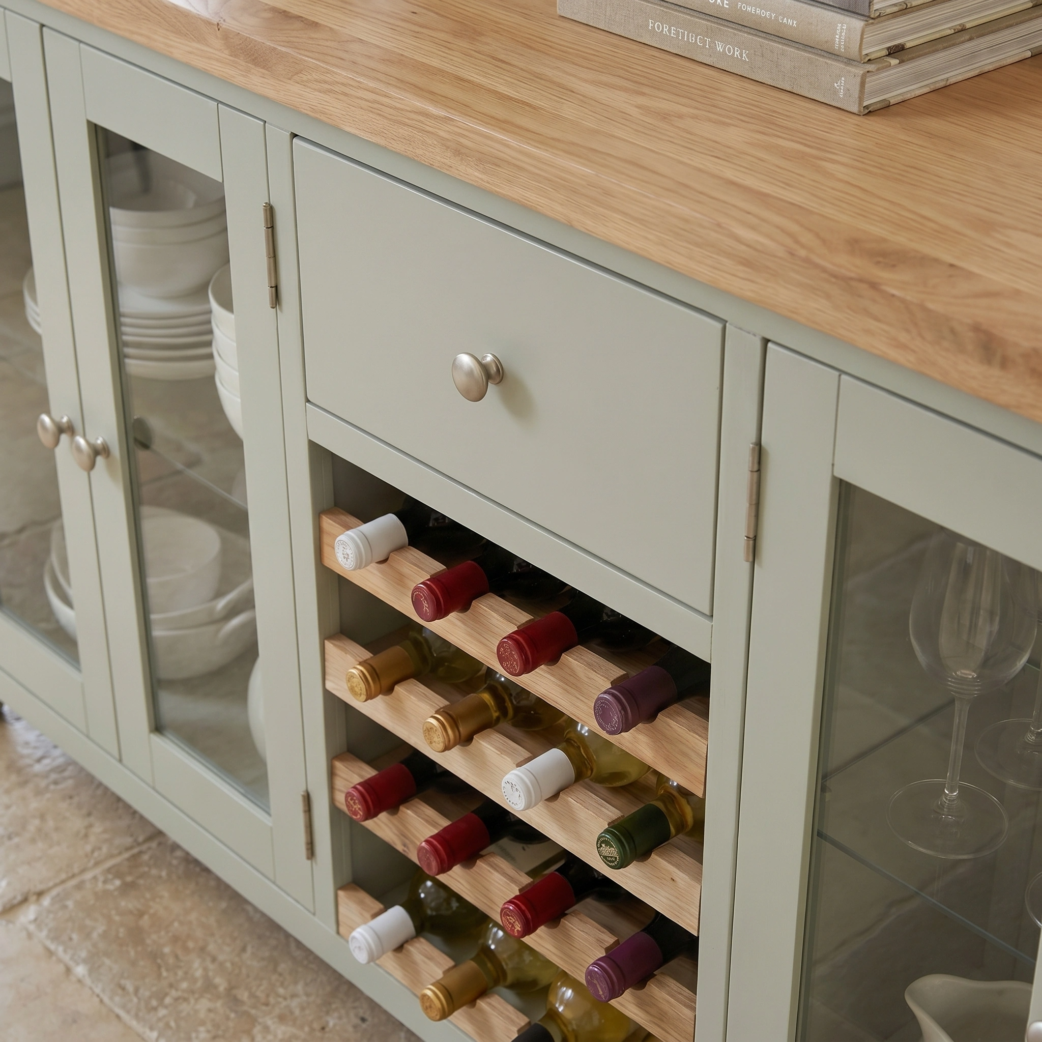 The Burford Grand Sideboard with Wine Rack in Sage Green features a built-in wooden wine rack for bottles and glass doors to elegantly display your dishes.