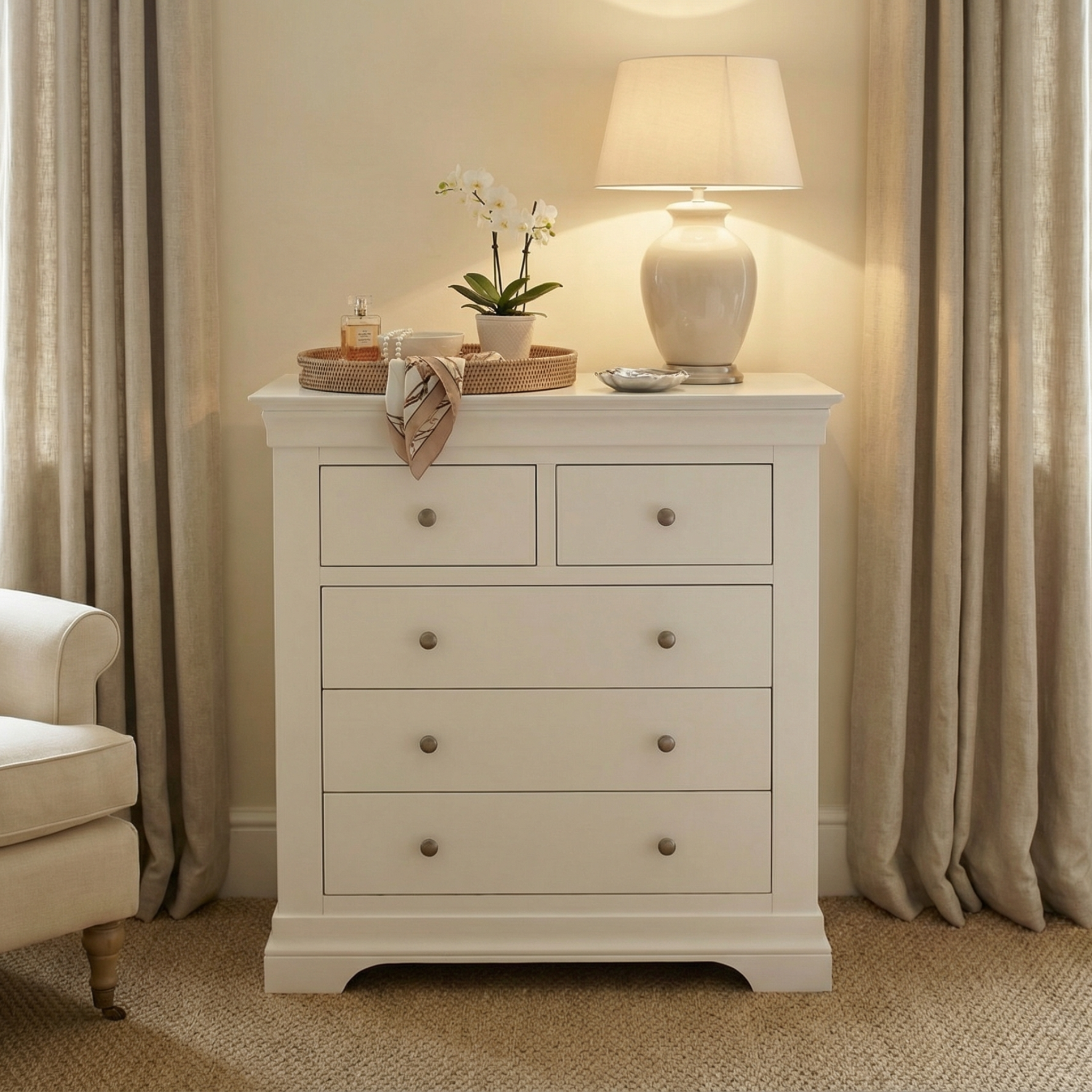 The Chalbury 2 Over 3 Chest of Drawers in Warm White, topped with a lamp, orchid, and tray, sits between beige curtains and adds charm to this cozy room.