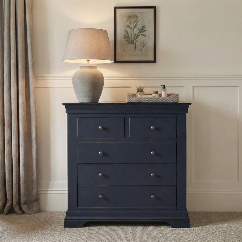 A Chalbury 2 Over 3 Chest of Drawers in Dusky Black sits beneath a lamp and botanical print, next to beige curtains.