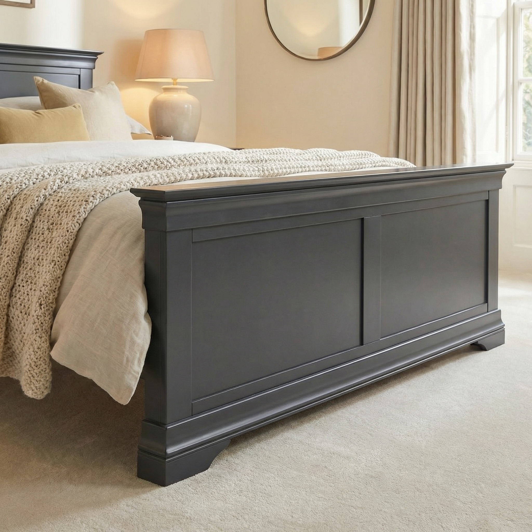 A cozy bedroom with the Chalbury 5ft High-End Kingsize Bed Frame in dusky black, complemented by neutral bedding, a lamp, and a round wall mirror.