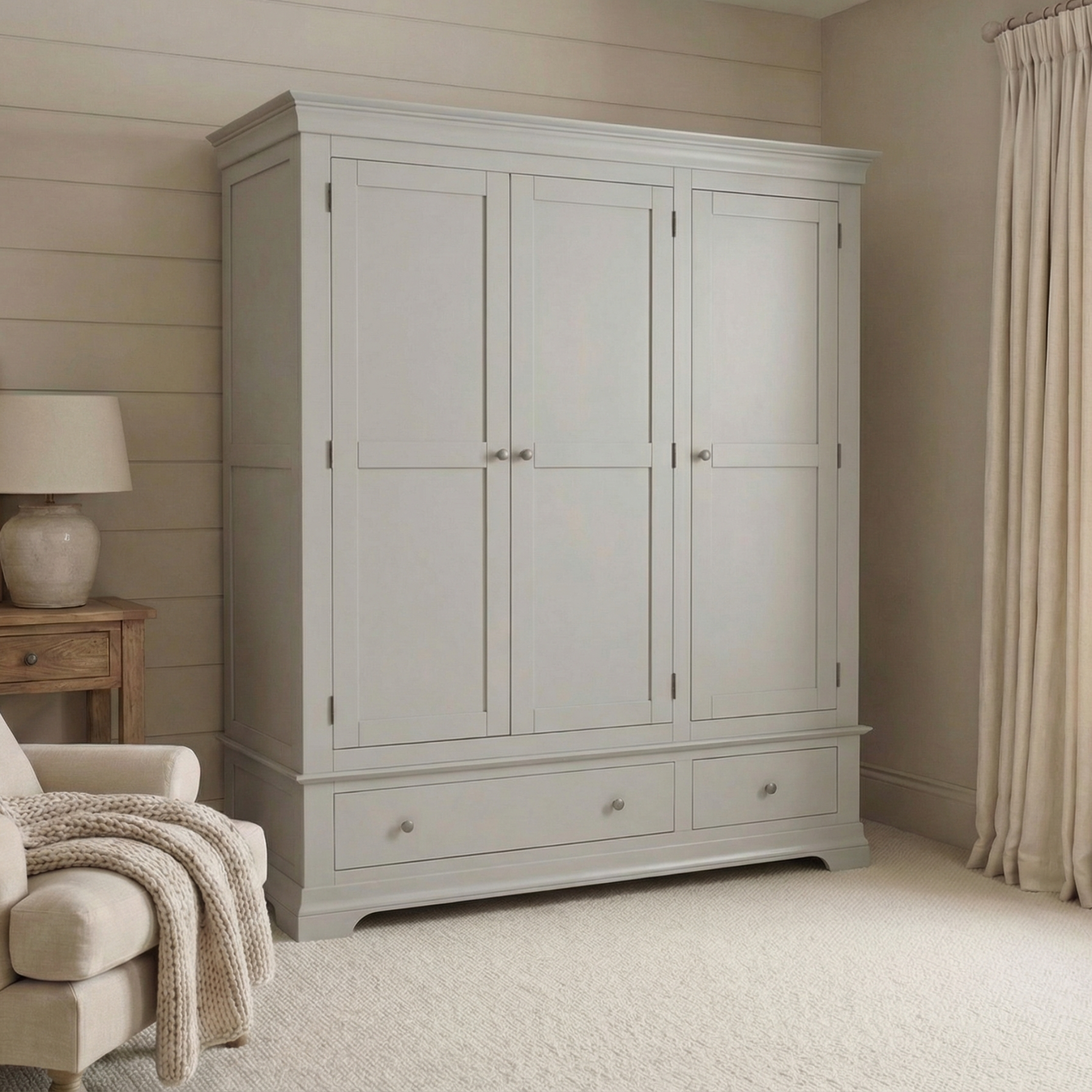 The Chalbury Triple Wardrobe in Pebble Grey, featuring three doors and two drawers, provides elegant and ample storage for your bedroom.