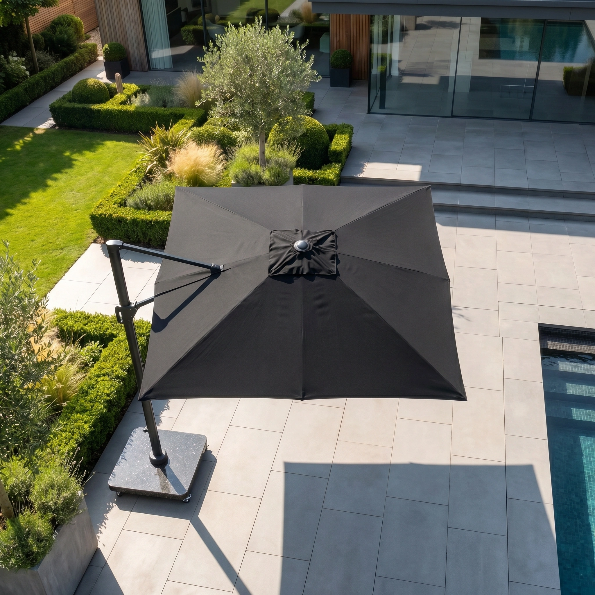 The Challenger T2 Premium 3.5m x 2.6m Rectangular Cantilever Parasol in Black features 360-degree rotation to shade your modern landscaped backyard’s tiled poolside area.